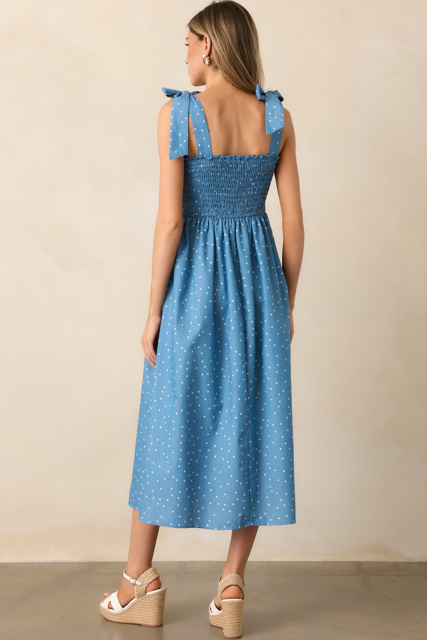 The back showcases the smocked bodice, self-tie straps, and flowing skirt, completing the elegant yet relaxed design.