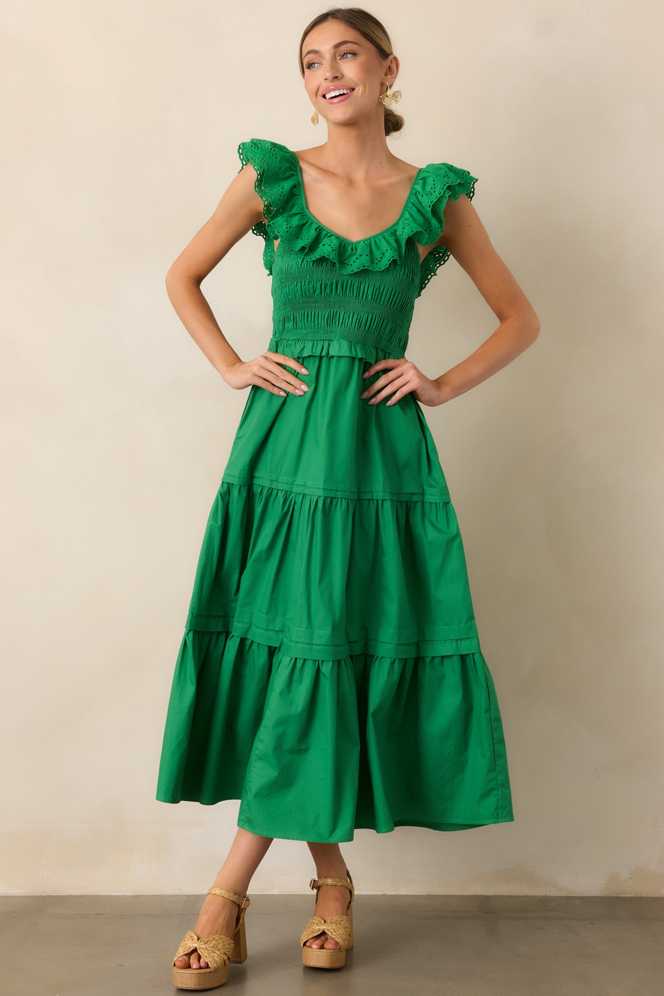 A charming green maxi dress featuring a delicate ruffled V-neckline, a stretchy smocked bodice, and a tiered skirt with a breezy feel.