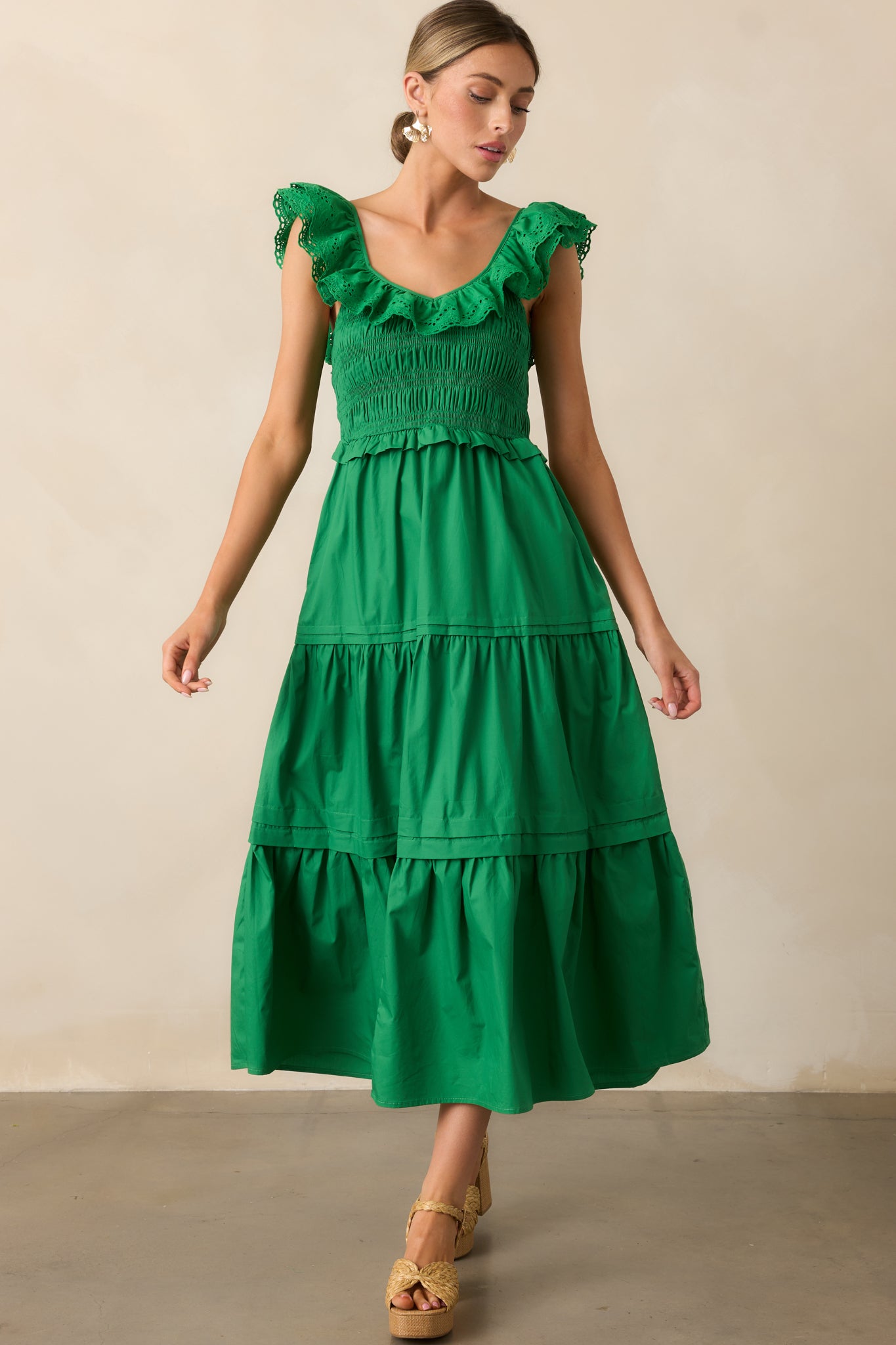  This maxi dress in a rich green hue showcases a ruffled V-neckline, flattering smocked bodice, and a tiered skirt with subtle movement.