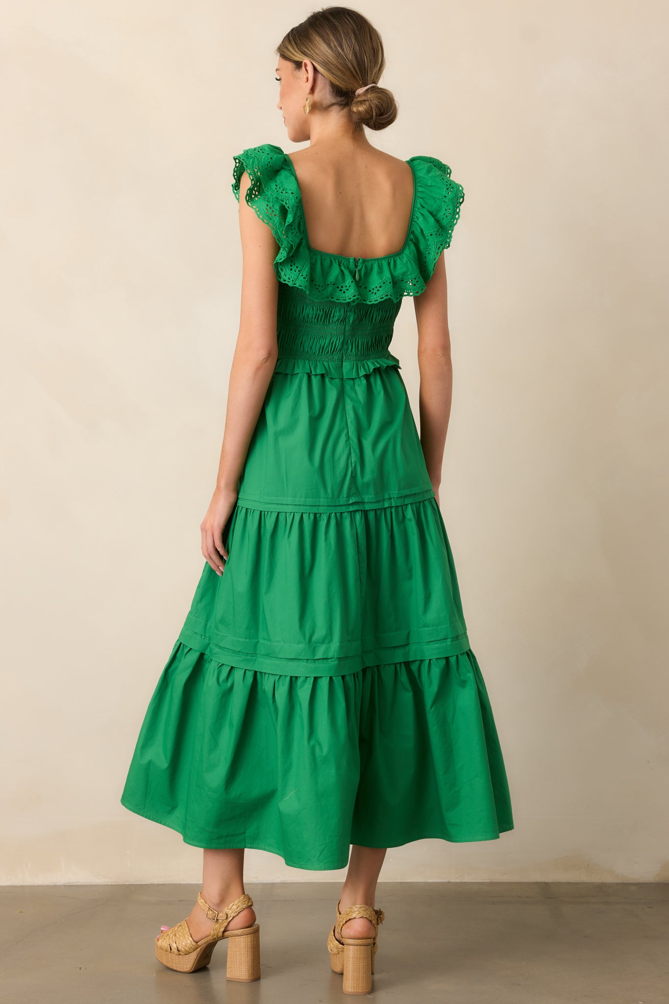  The back view of the green maxi dress, showing its flowing tiered skirt and seamless fit.
