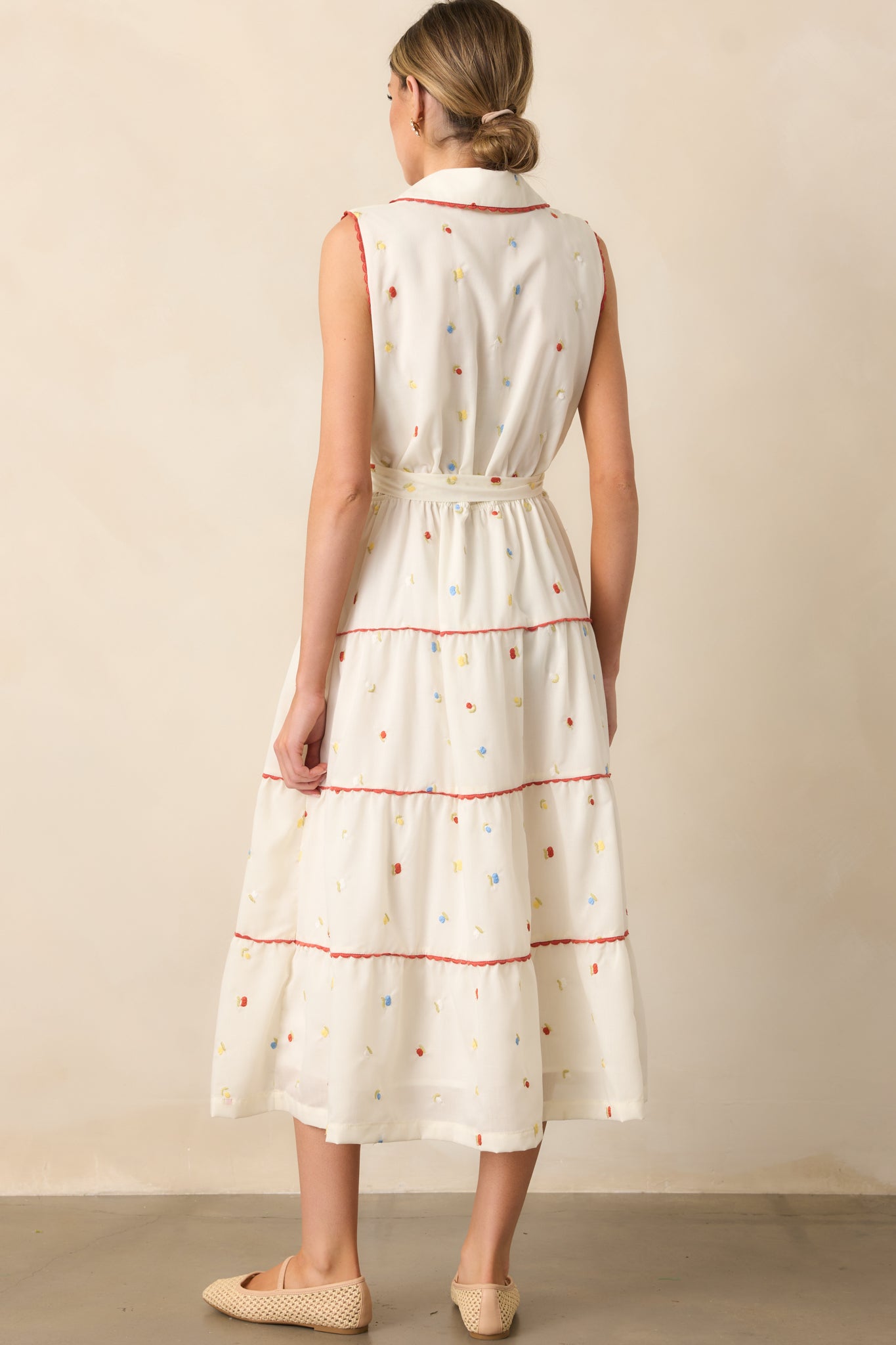 The back showcases the collared neckline, self-tie waist, and flowing skirt, completing the timeless and feminine design.