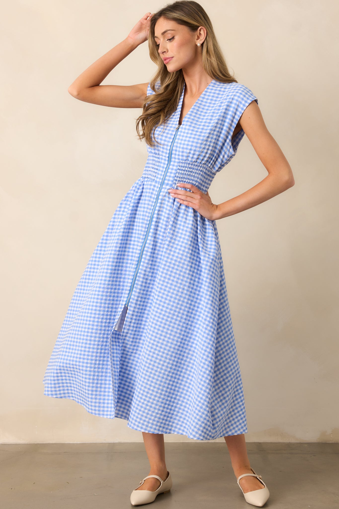  Designed with a full-length zipper front and a subtle front slit, this dress blends classic gingham with modern details.