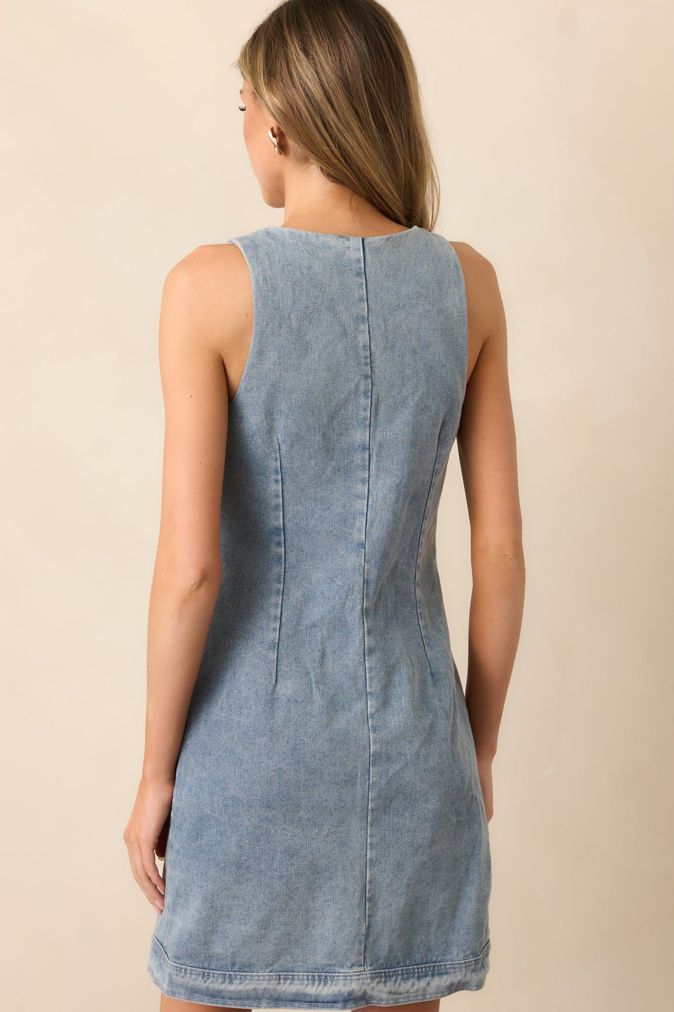 A view of the mini dress from behind, showcasing the smooth, streamlined back and sleeveless cut.