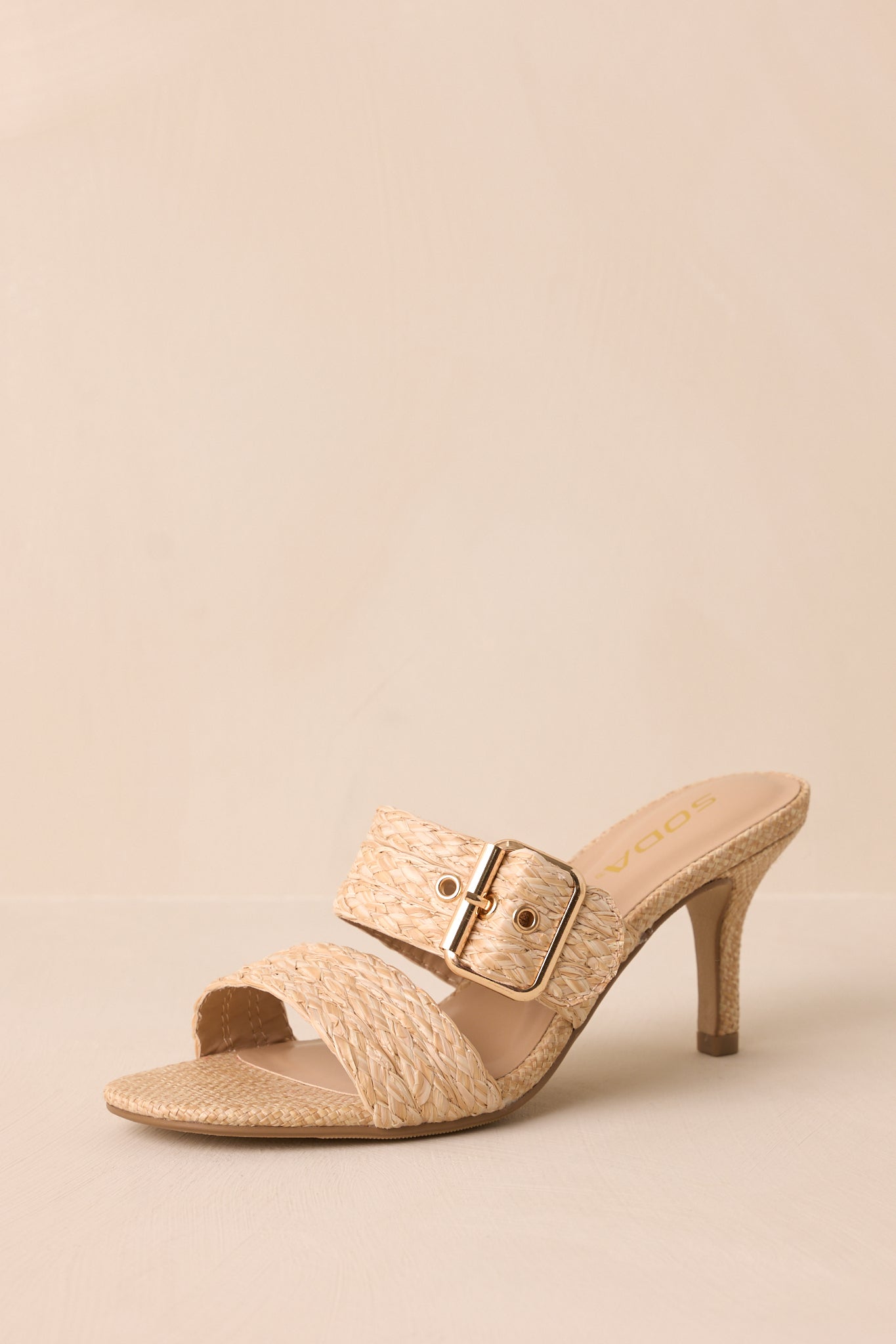  A slightly angled perspective showing the balance between the straps, gold buckle, and the structured heel.