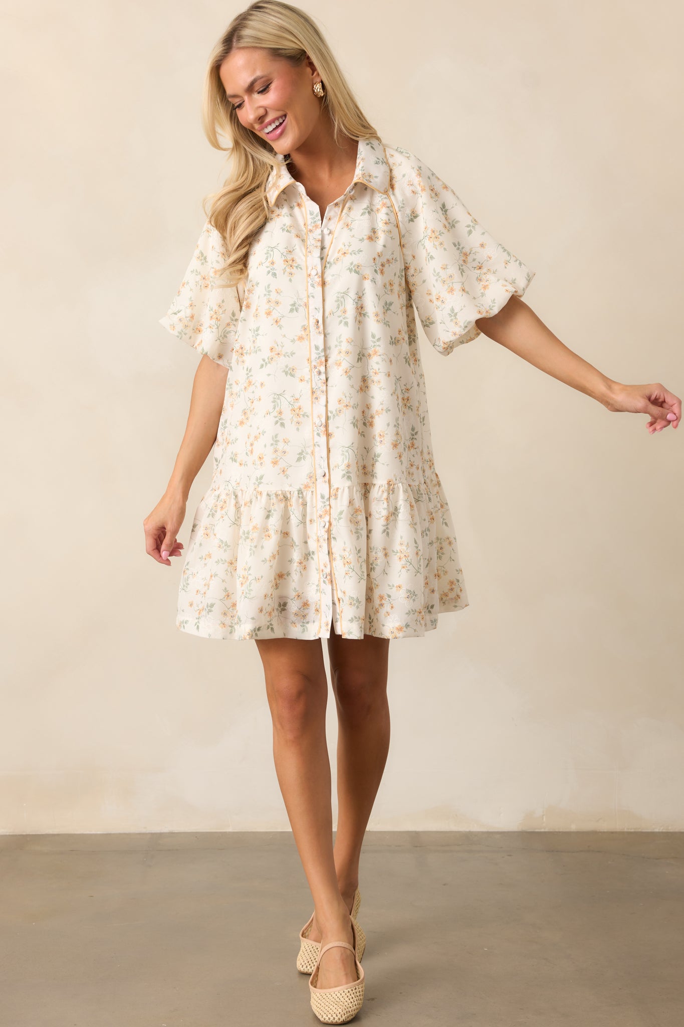 A charming yellow dress showcasing a button front design, soft puff sleeves, and a ruffled hem for added movement.