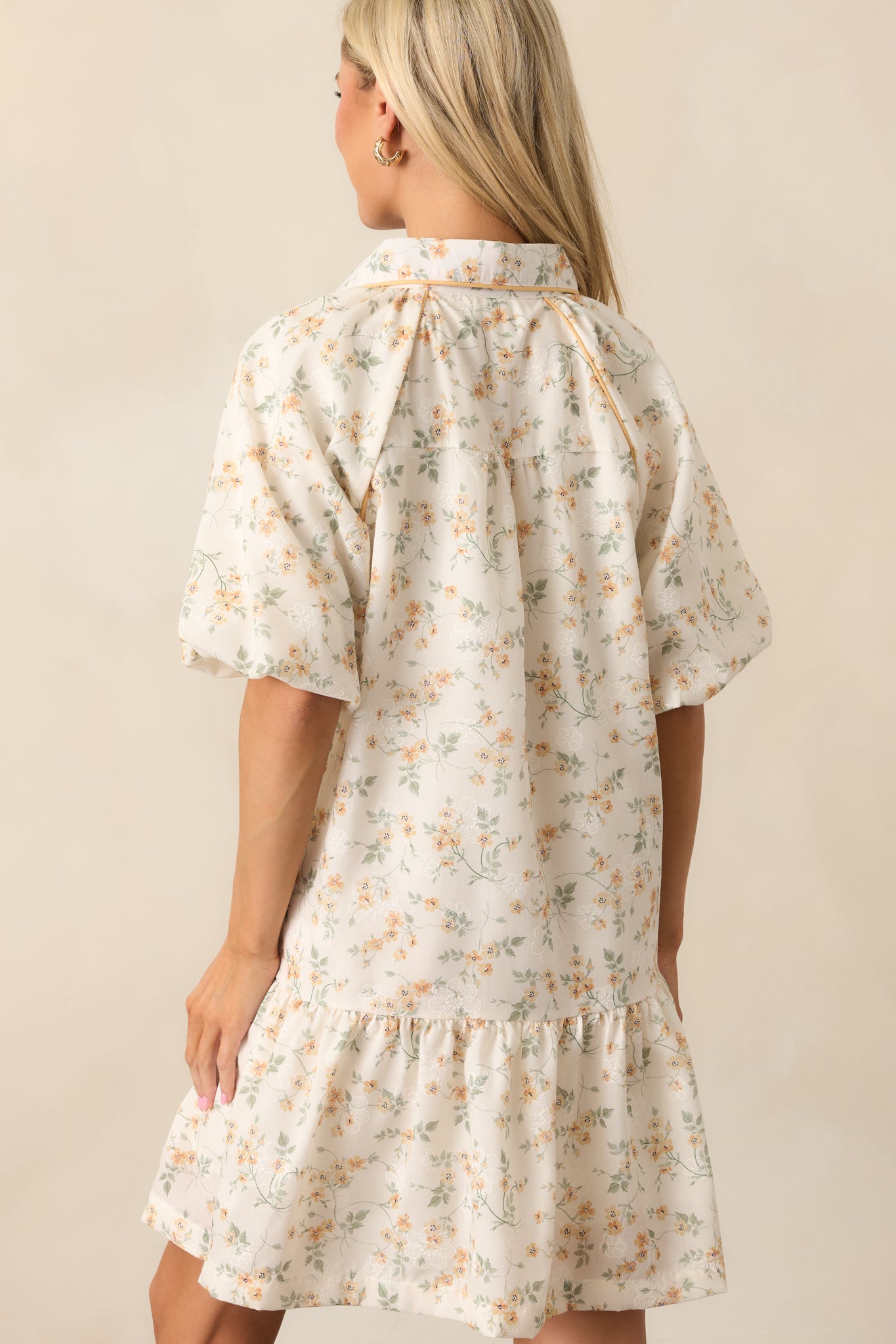 A back view of the yellow dress, showing the smooth silhouette and continuation of the ruffled hem.