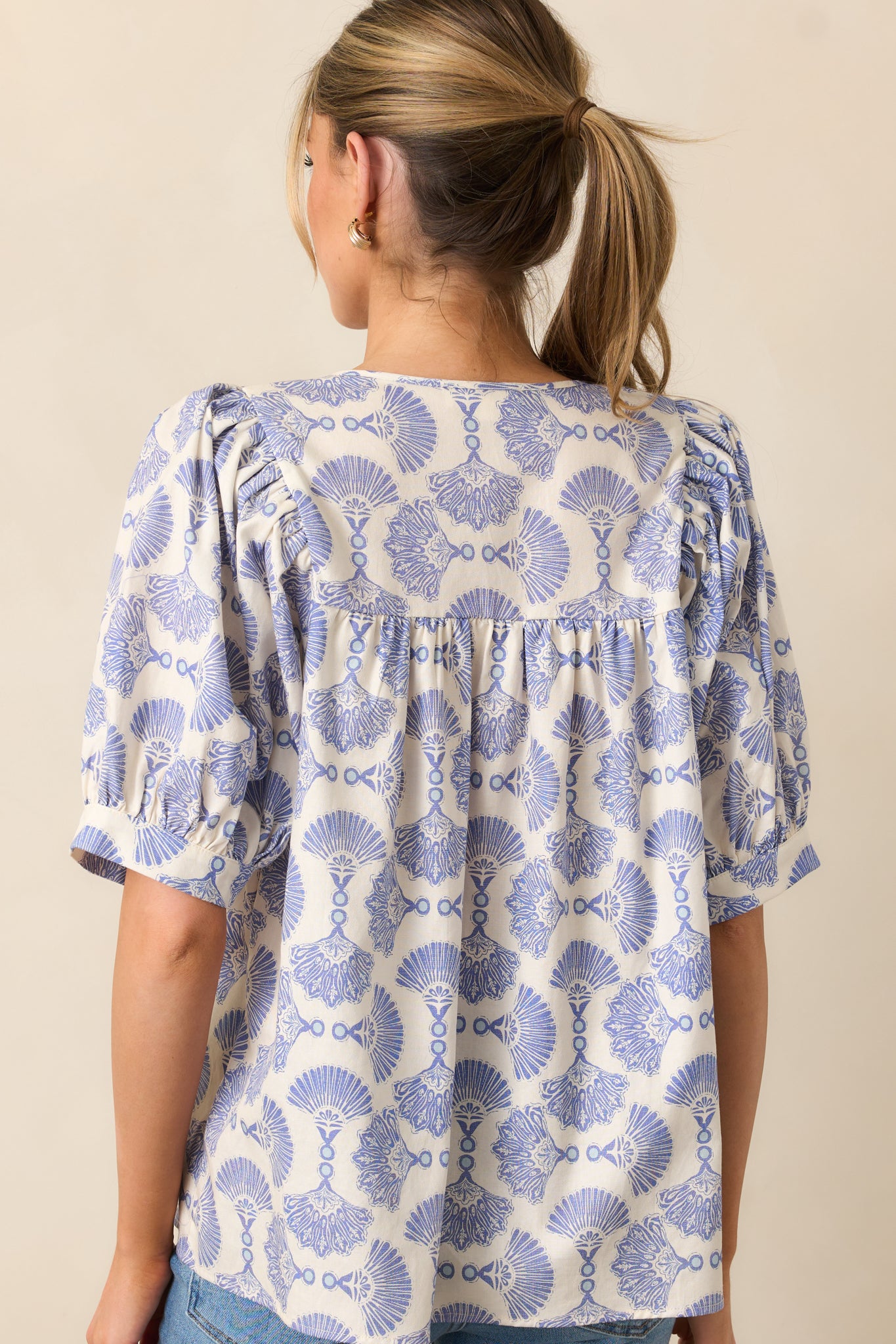 The back of the blouse highlights the continuous print, smooth drape, and relaxed silhouette.