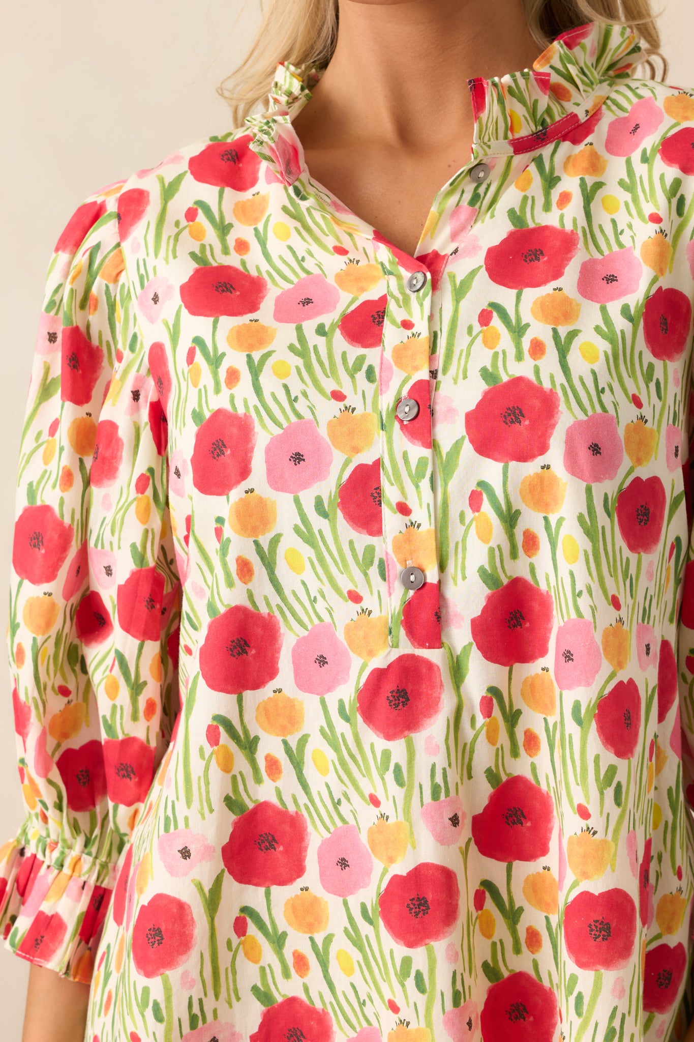 A close-up of the three functional buttons down the front, adding a refined, classic touch to the red floral dress