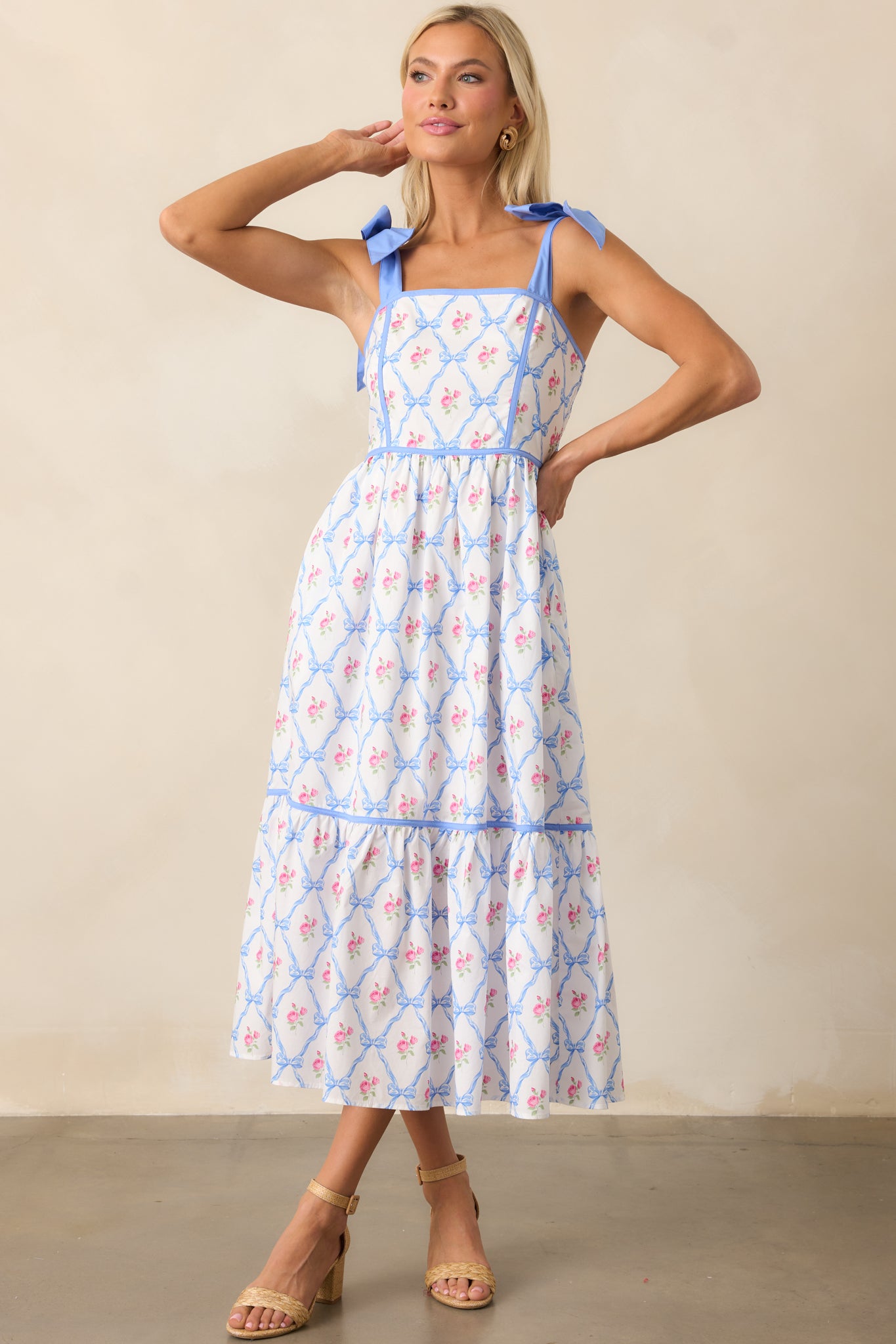  A full view of the blue dress, highlighting the self-tie blue ribbon straps, square neckline, and smocked back. The functional pockets complete the casual, comfortable look.