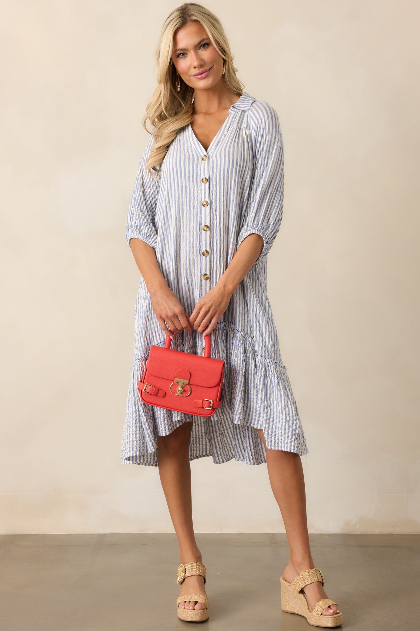 Vertical stripes run throughout the dress, complementing the crisp collar and button-down front.