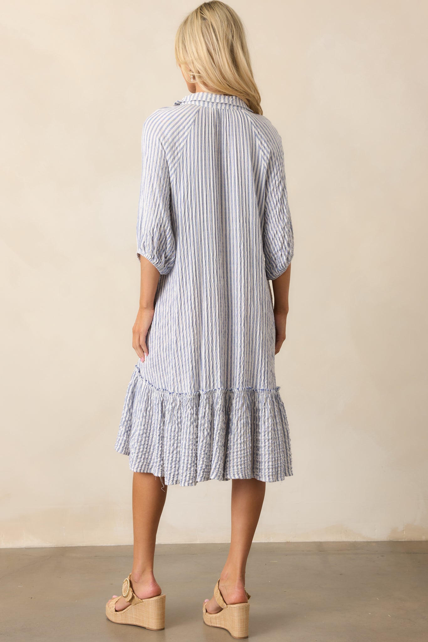 The back of the dress showcases the drop waist silhouette and continuous vertical stripe pattern.