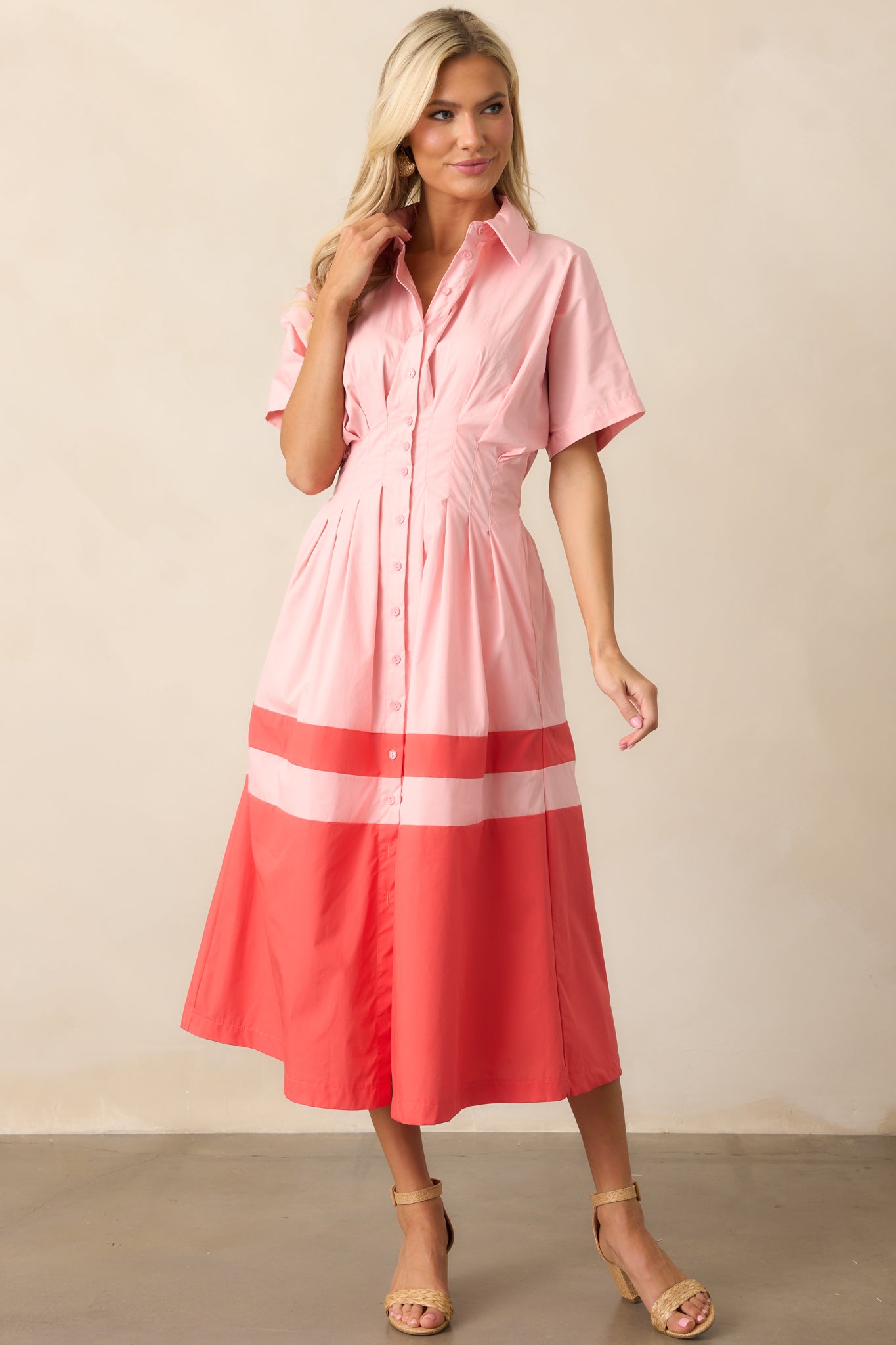 Another full-length view of the pink midi dress, showcasing the overall design, including the short sleeves and color block details.