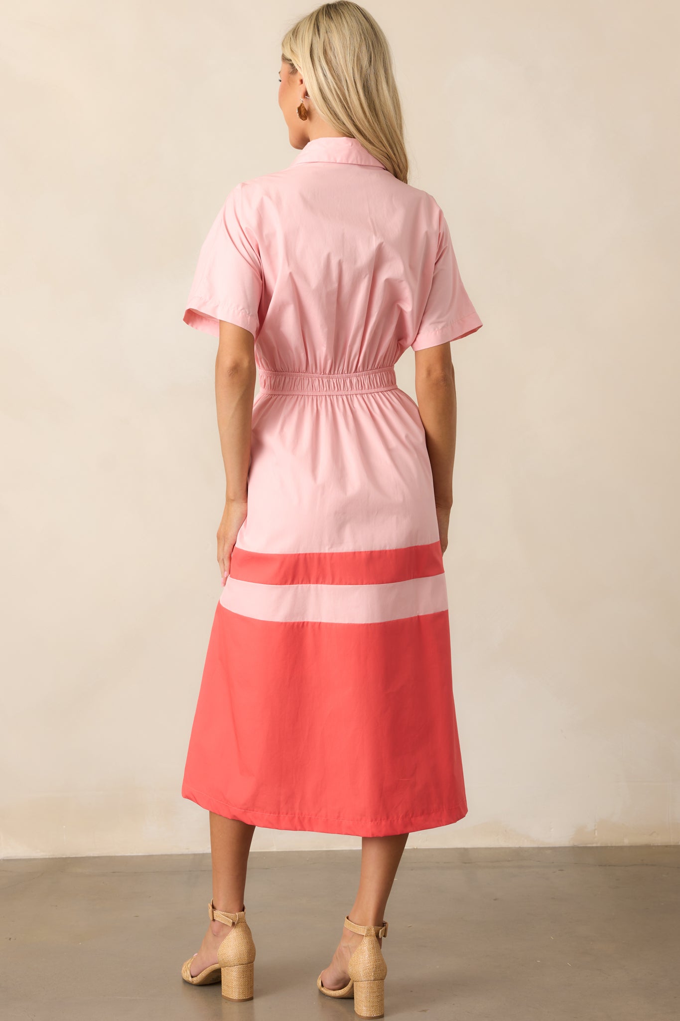 The back of the pink midi dress, highlighting the coral color block skirt and clean lines of the design.