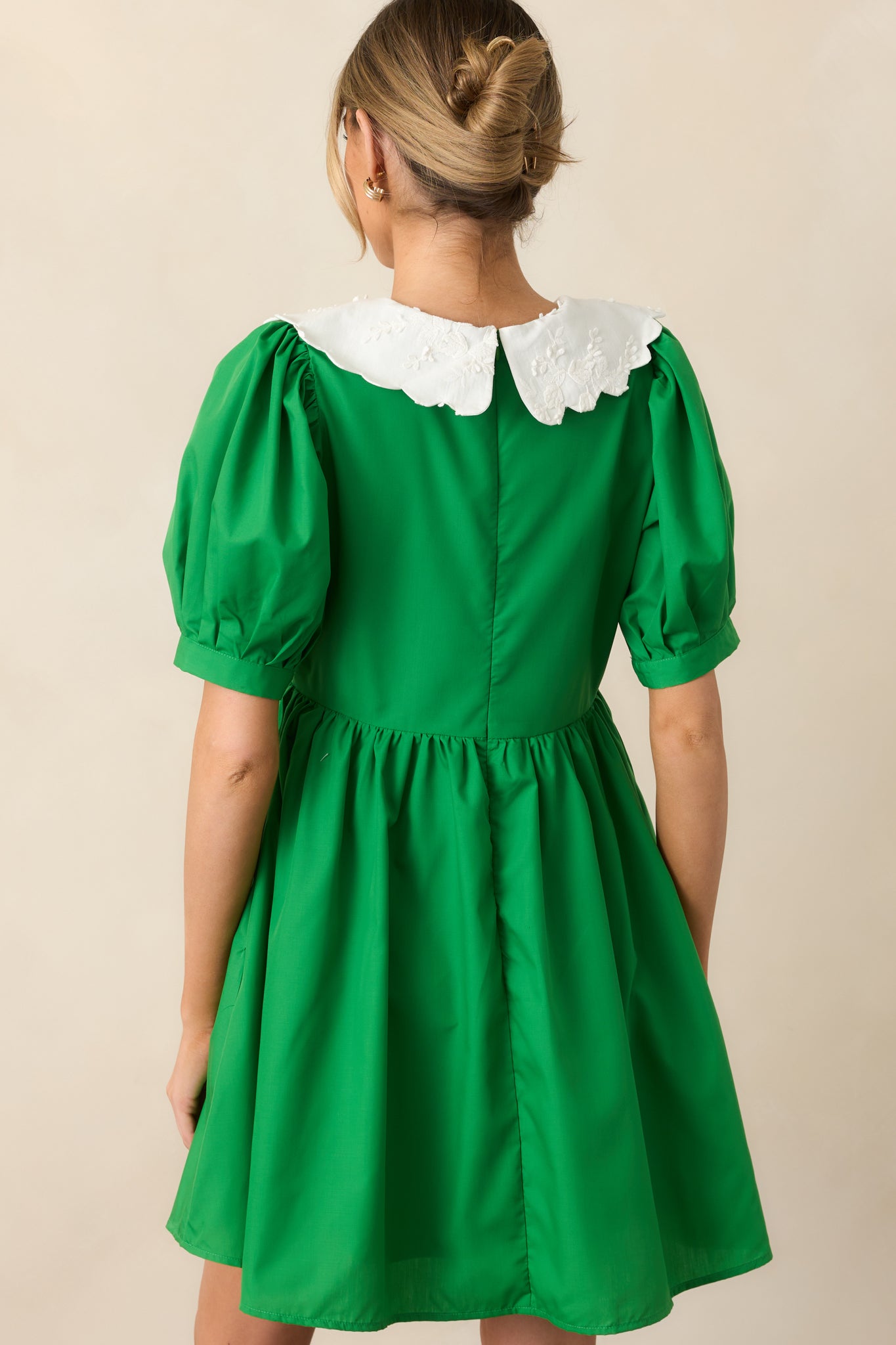 The back of this green dress continues the babydoll style, with a simple, flowing silhouette and puff sleeves.