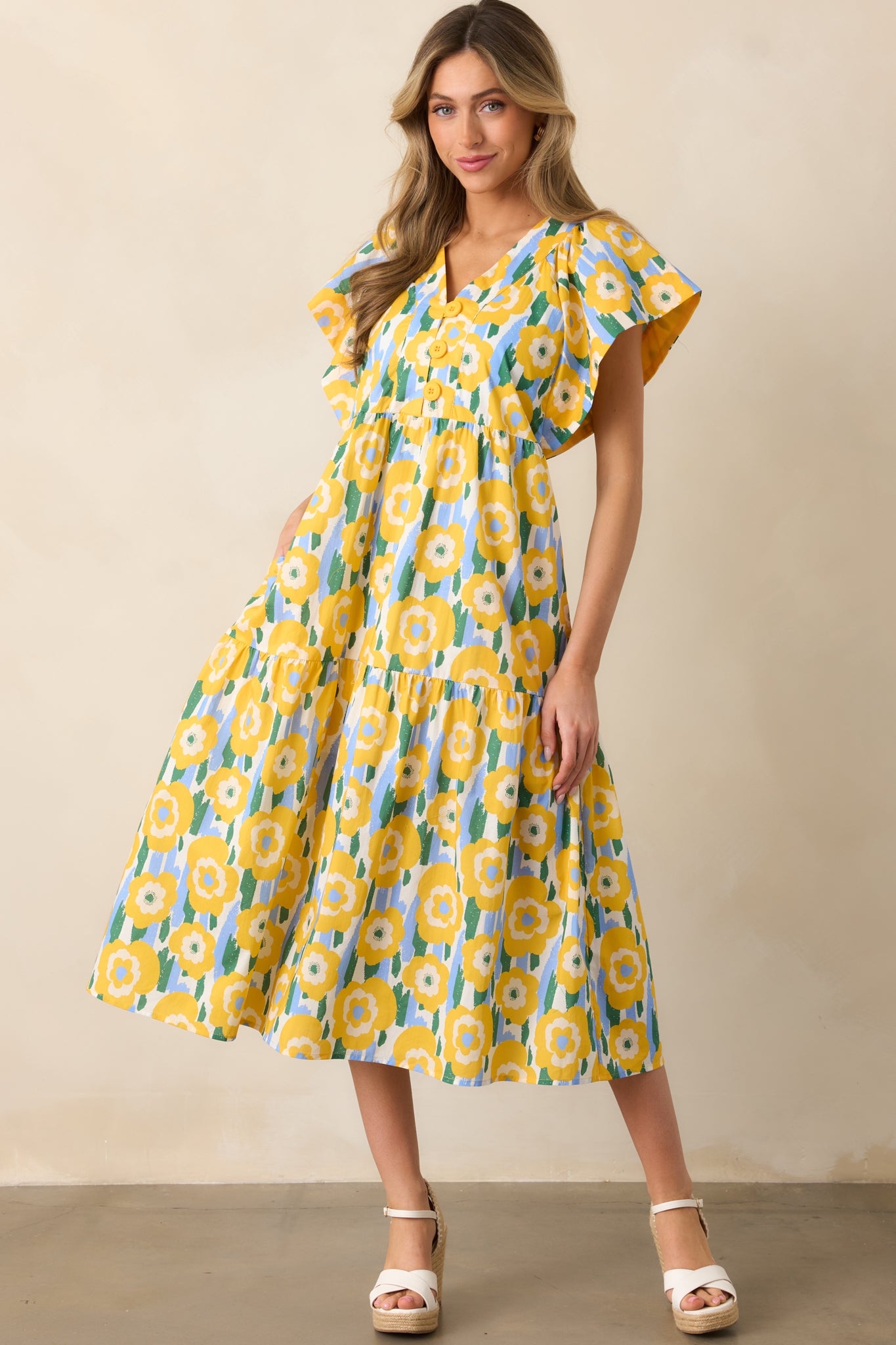 Yellow dress featuring flutter sleeves and a tiered design, offering a playful, flowy look perfect for casual wear.