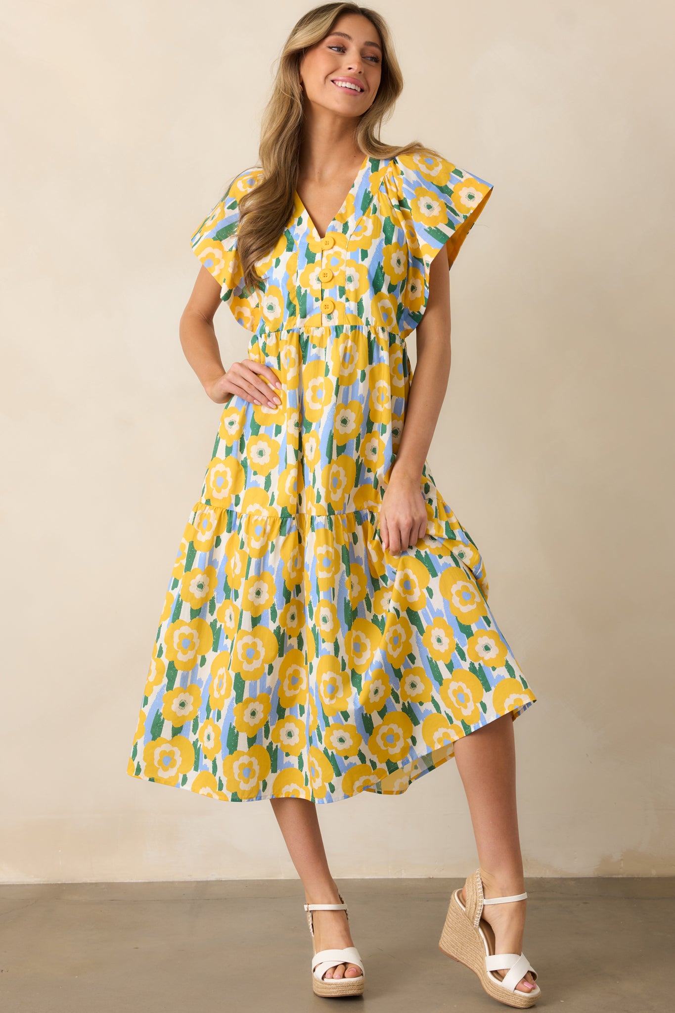 Functional buttons down the front and flutter sleeves create a soft, feminine vibe in this yellow V-neck dress.