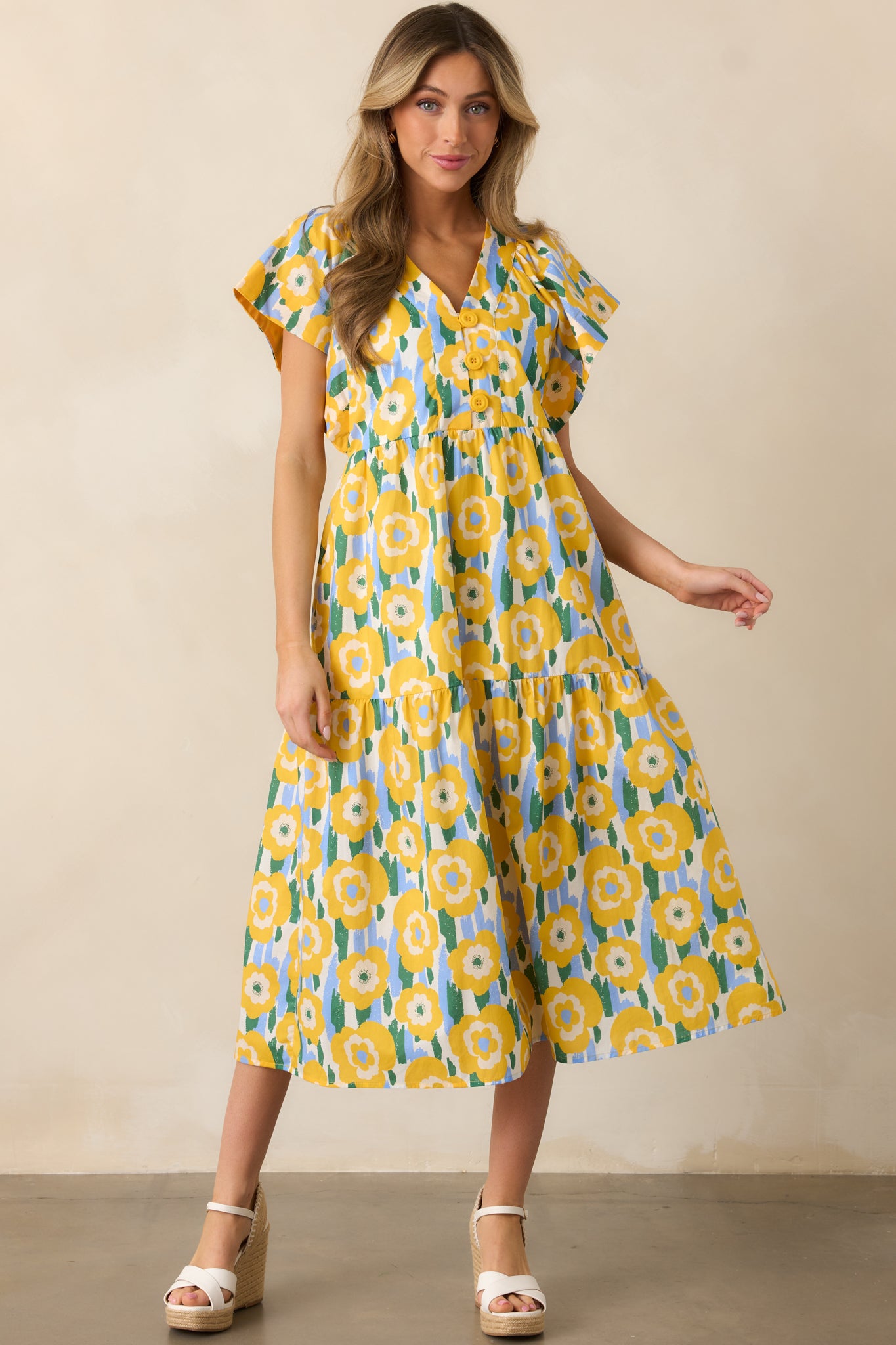 A relaxed yet flattering yellow dress with a tiered design, flutter sleeves, and practical front pockets.