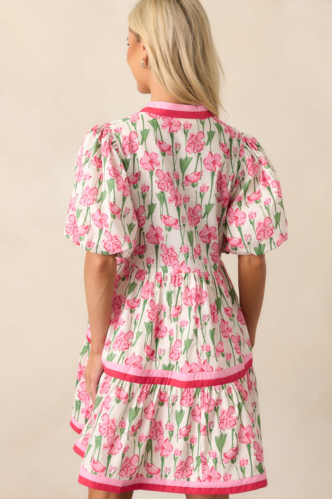 The back of this pink dress continues the tiered design with a simple, seamless look and playful puff sleeves.