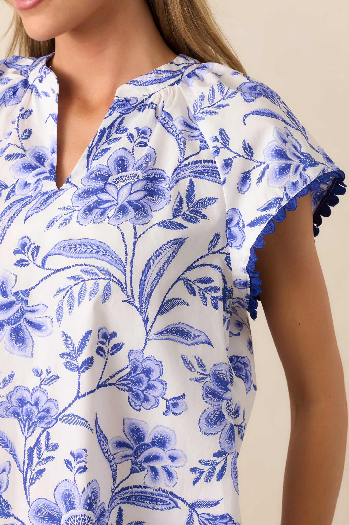 A closer look at the blue floral pattern, ricrac trim, and stitching highlights the blouse’s craftsmanship.