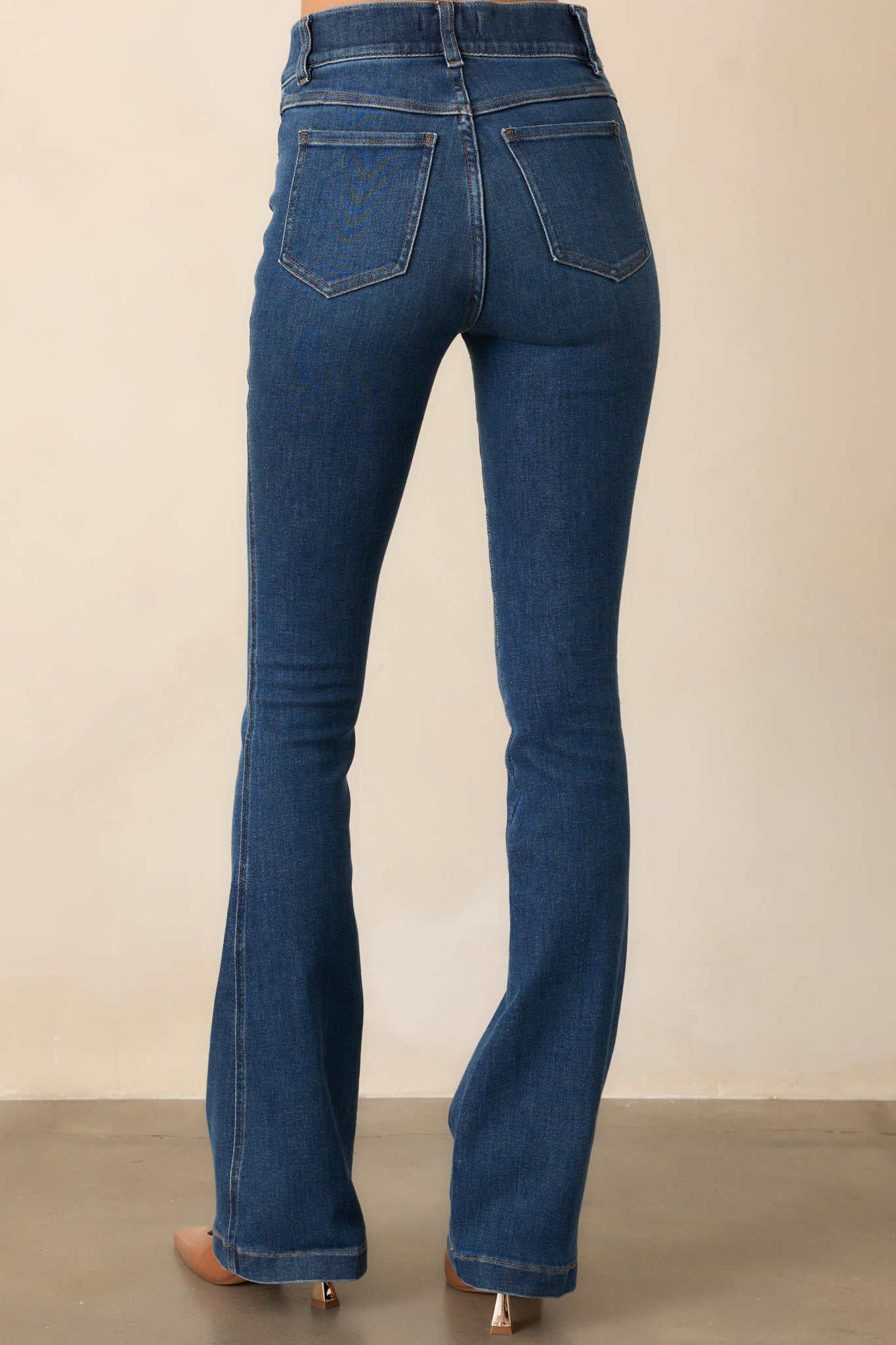 Functional back pockets add a practical touch to these fitted flare jeans, complementing the curve-hugging silhouette.