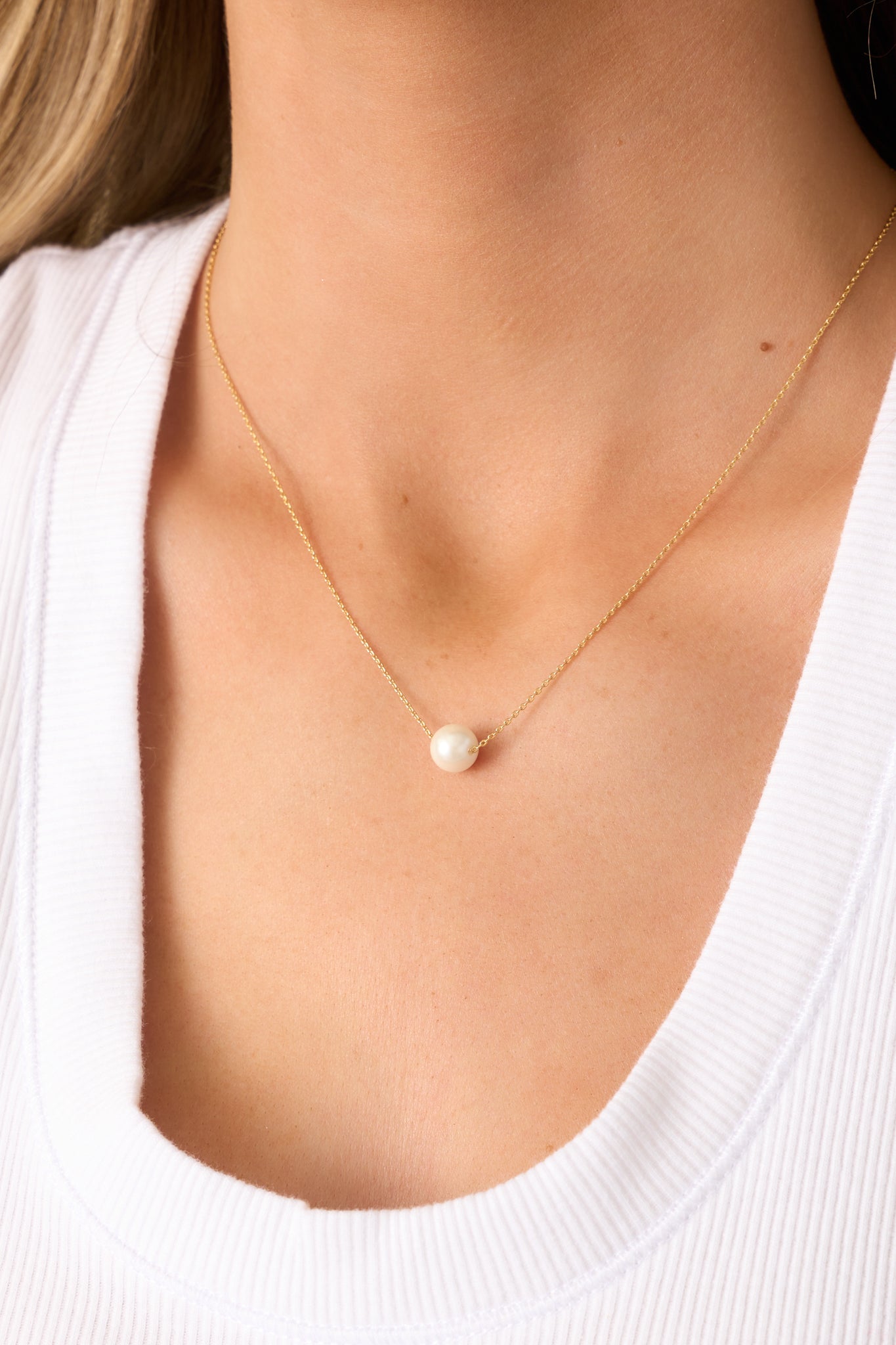 The ivory faux pearl bead sits gracefully on the fine gold chain, offering a timeless and refined look.