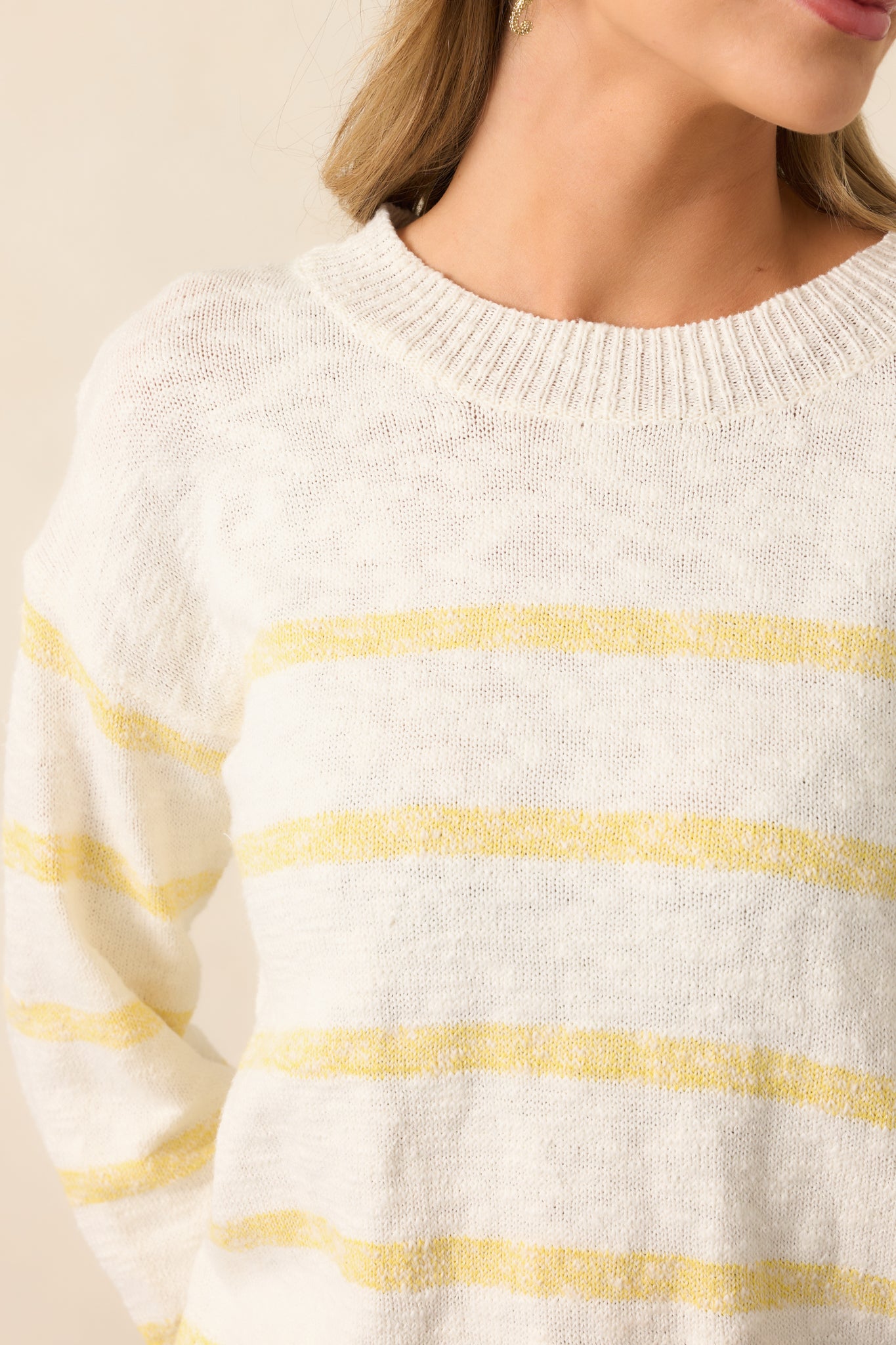 A detailed view of the ribbed hemline and yellow stripe accents, showcasing the refined knit pattern.