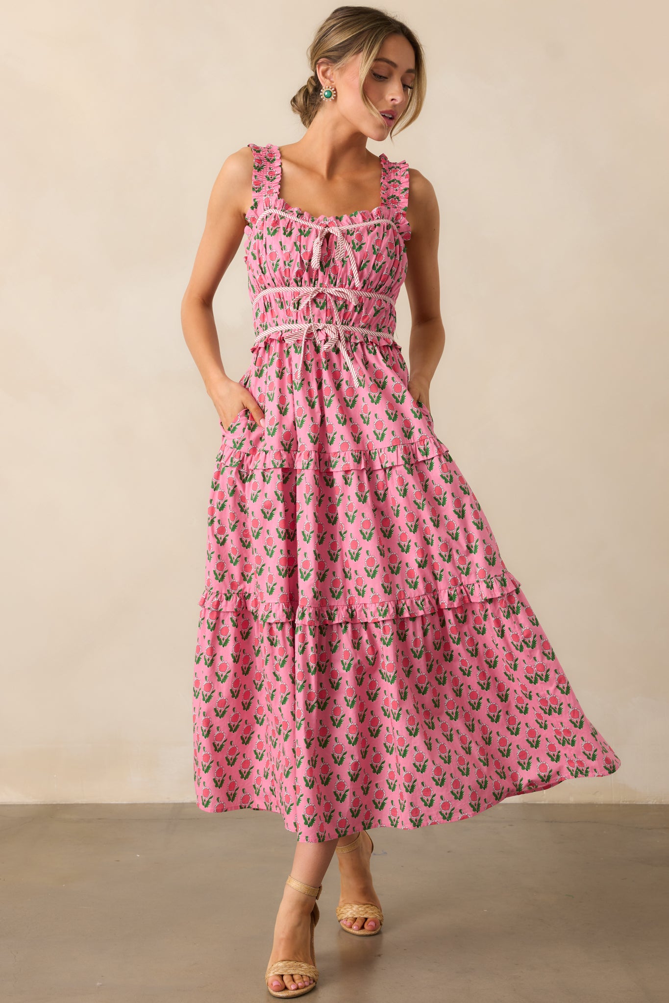 A fresh take on the pink dress with its tiered empire waist, ruffle tiers below, and a flattering bow tie accenting the waist for added definition.