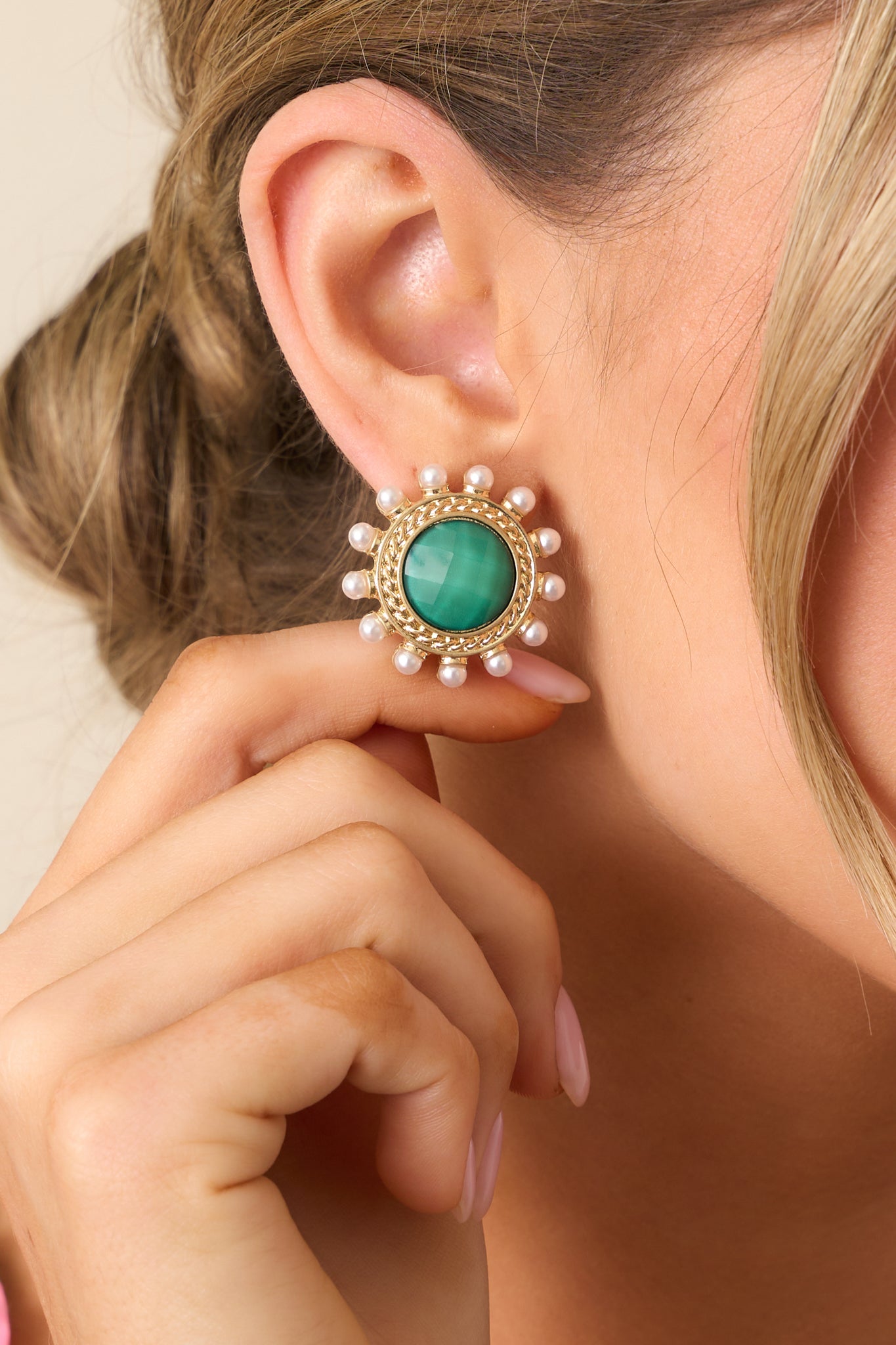 A detailed shot of the green and gold earrings, highlighting the pearlescent green center, gold braided border, and ivory faux pearls decorating the edges for a sophisticated touch.