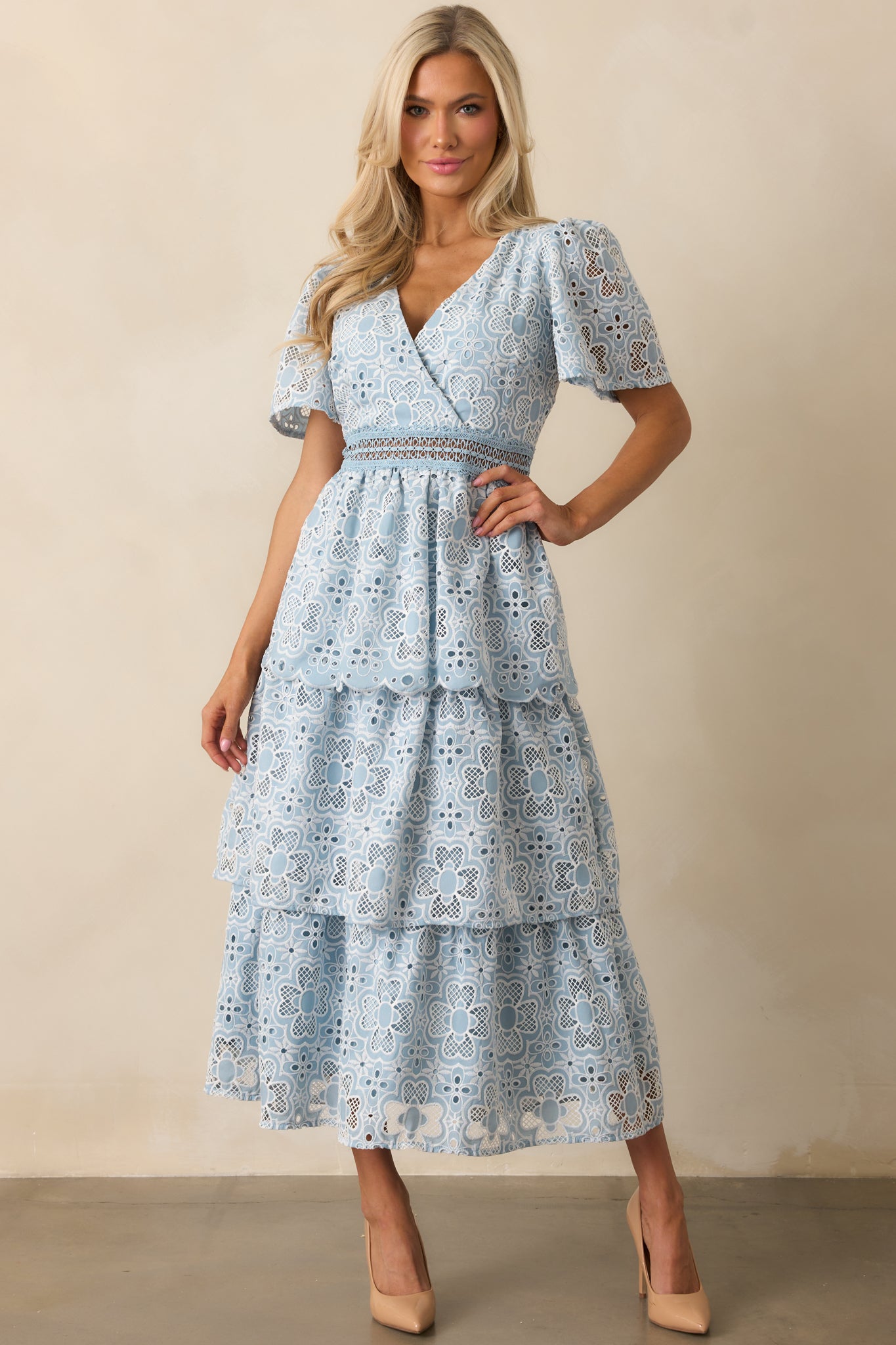 A graceful blue dress with a tiered skirt and delicate ladder trim at the waist, adding subtle detail