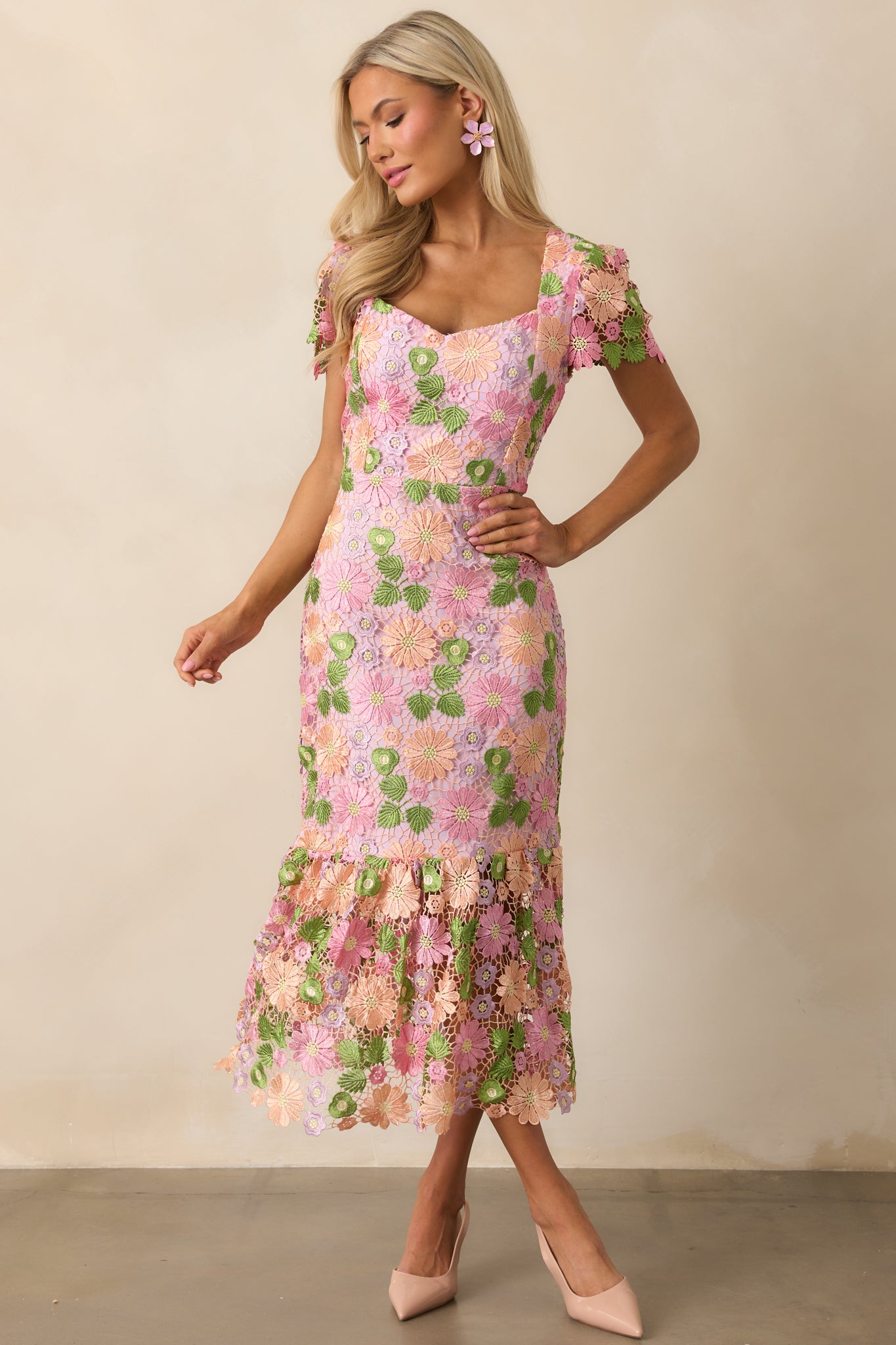 A fitted dress with intricate floral embroidery and a v-neckline, blending elegance with delicate details.