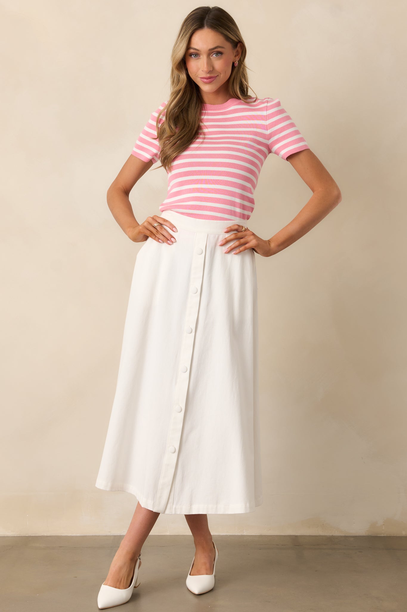 This striped pink top features a structured collar and a balanced mix of solid and patterned elements.