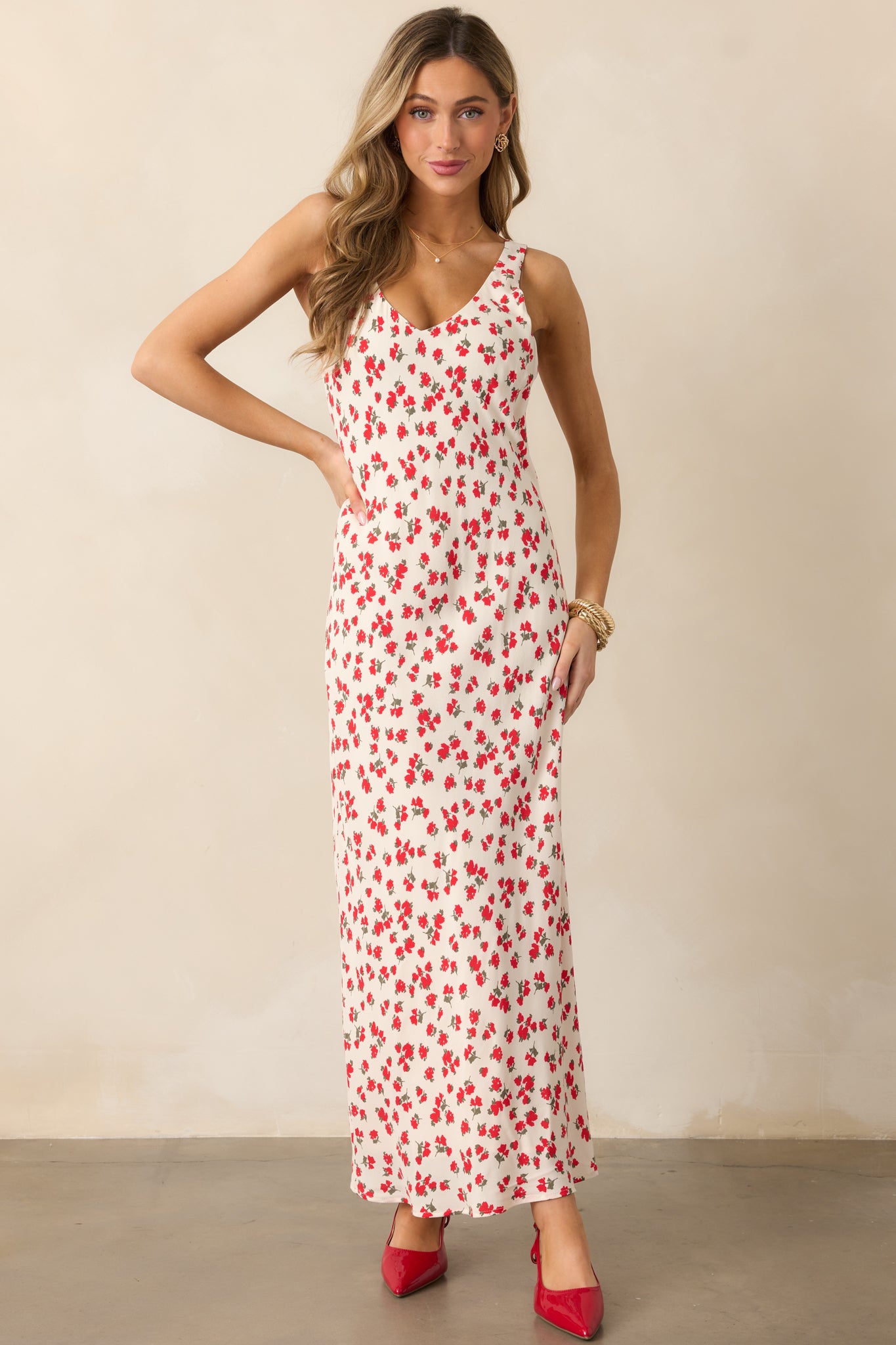 A front-facing view of the ivory dress, emphasizing the v-neckline, the feminine floral print, and the long flowy design that reaches the floor, showcasing the sleeveless cut.