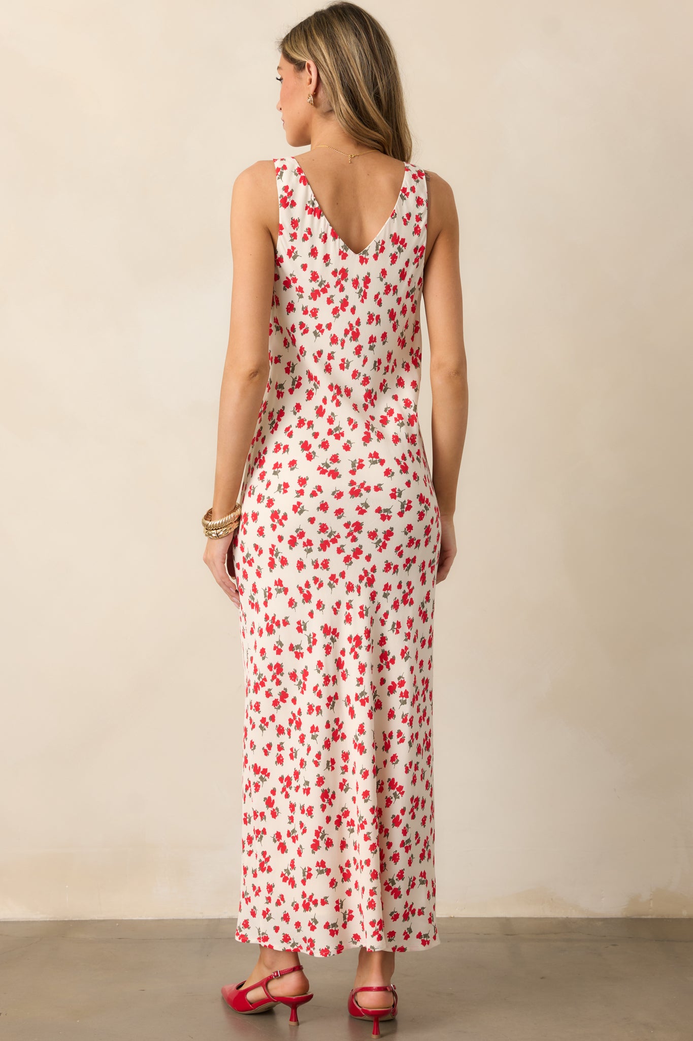 A back view of the ivory dress, showing its simple design with the same ditsy floral print extending down to the floor-length hem, and the sleeveless cut continuing the lightweight feel.