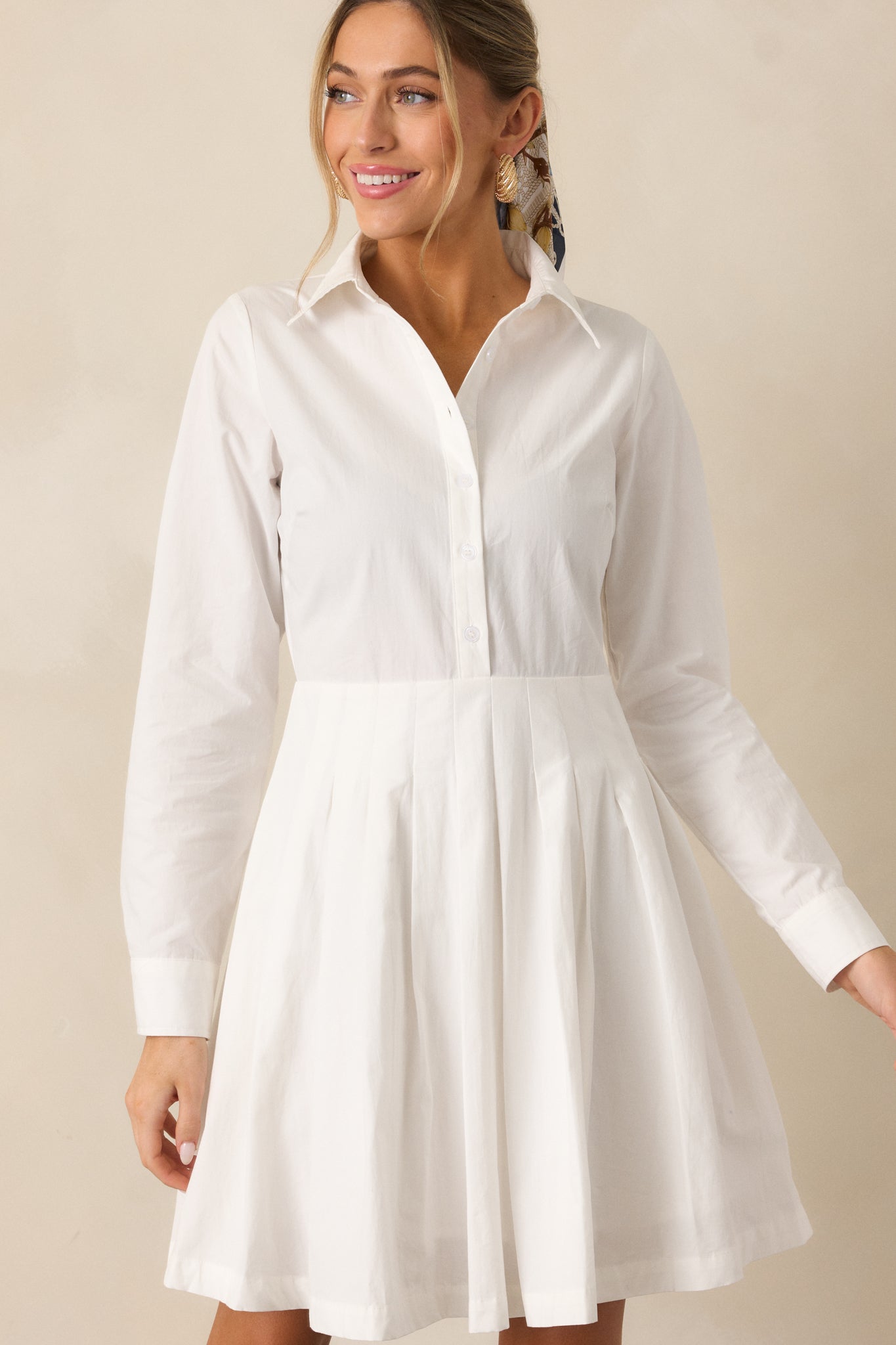 A detailed view of the white mini dress showcasing its smooth fabric and elegant simplicity.