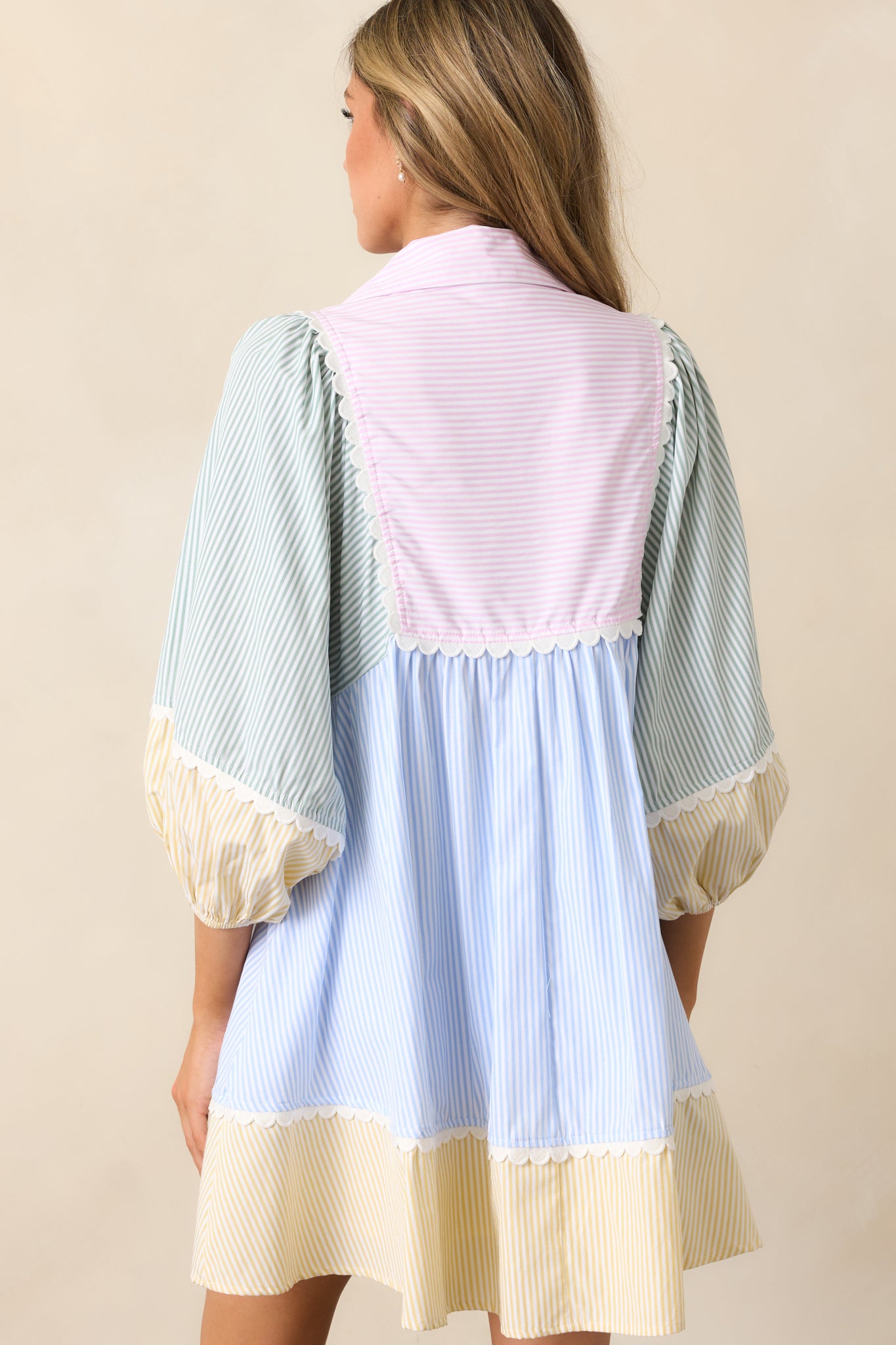 The back view of the pink dress reveals the clean finish, with the color block design continuing and the 3/4 sleeves, adding to the overall shape and style of the dress.