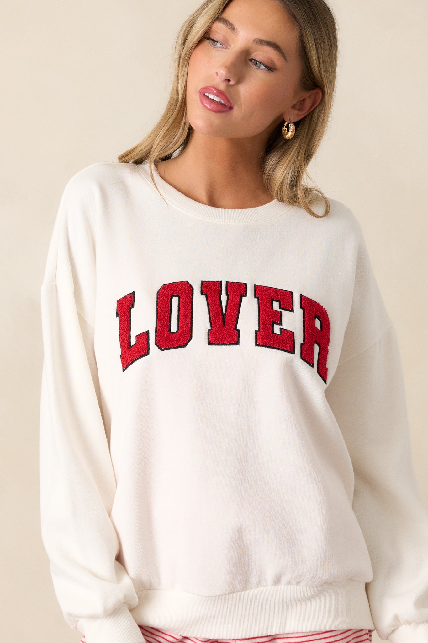 A close-up shot of the textured red "LOVER" script across the chest, with a focus on the fabric’s texture and the crew neckline.