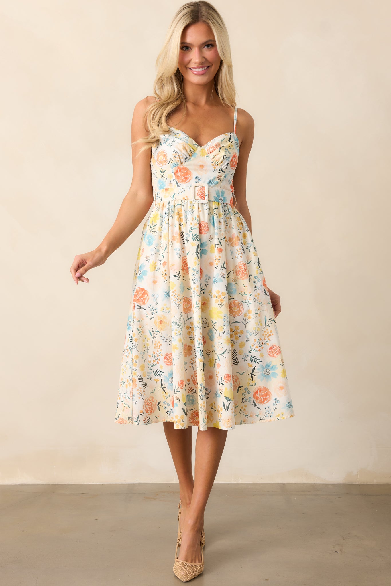  A front-facing shot of the ivory dress with its beautiful floral print, smocked back panel, and optional matching belt, perfect for a stylish, casual look.