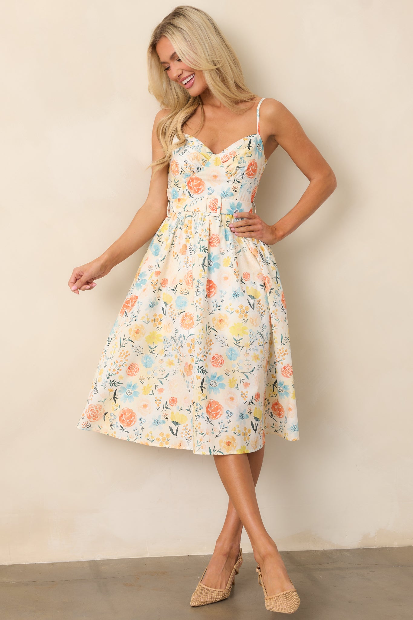  The ivory dress with a vibrant multicolor floral pattern, adjustable straps, and an optional matching belt, showcasing its elegant, flowy design.