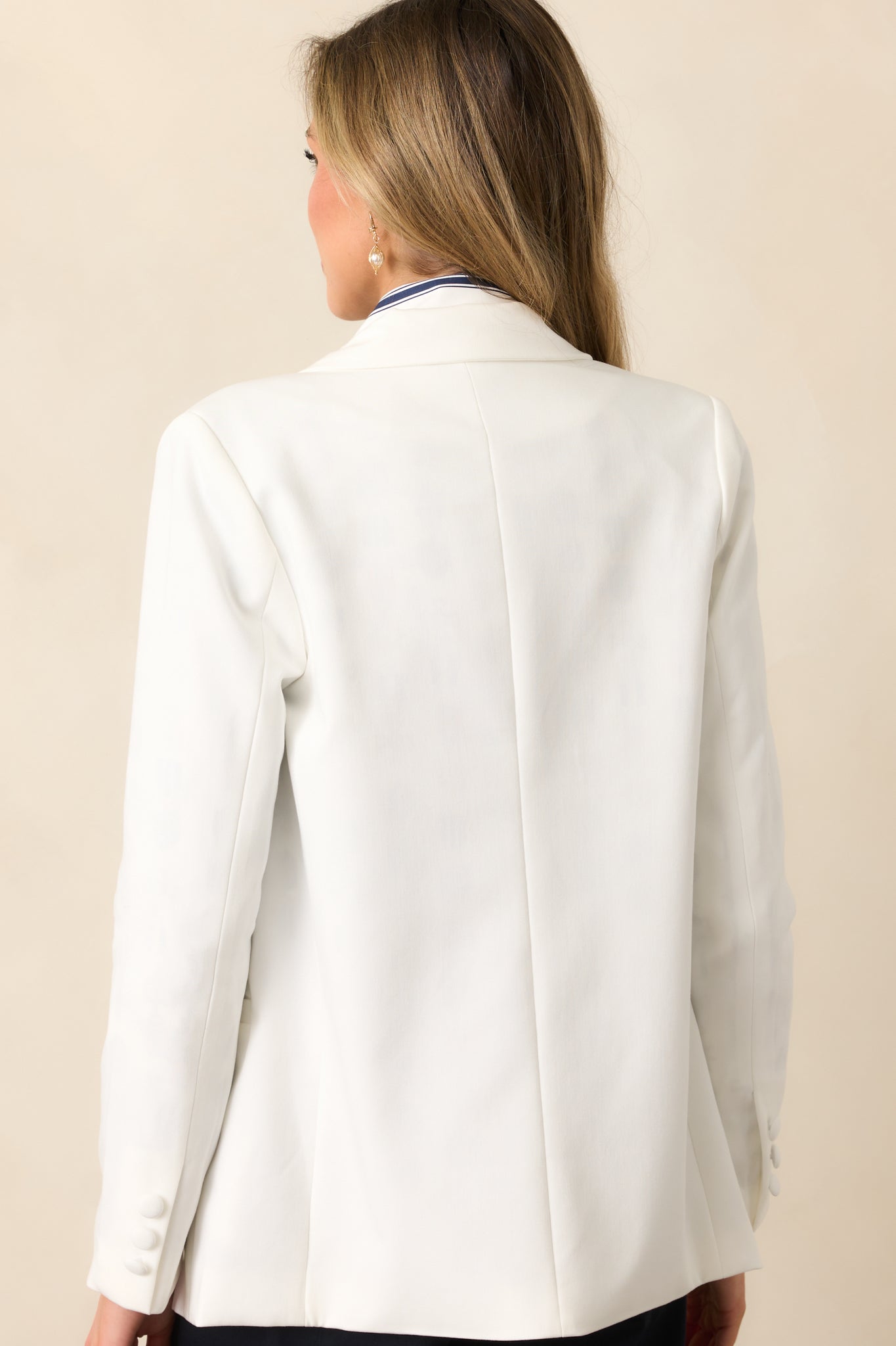 A back view showcasing the clean lines, lightweight shoulder pads, and tailored fit of the white blazer.