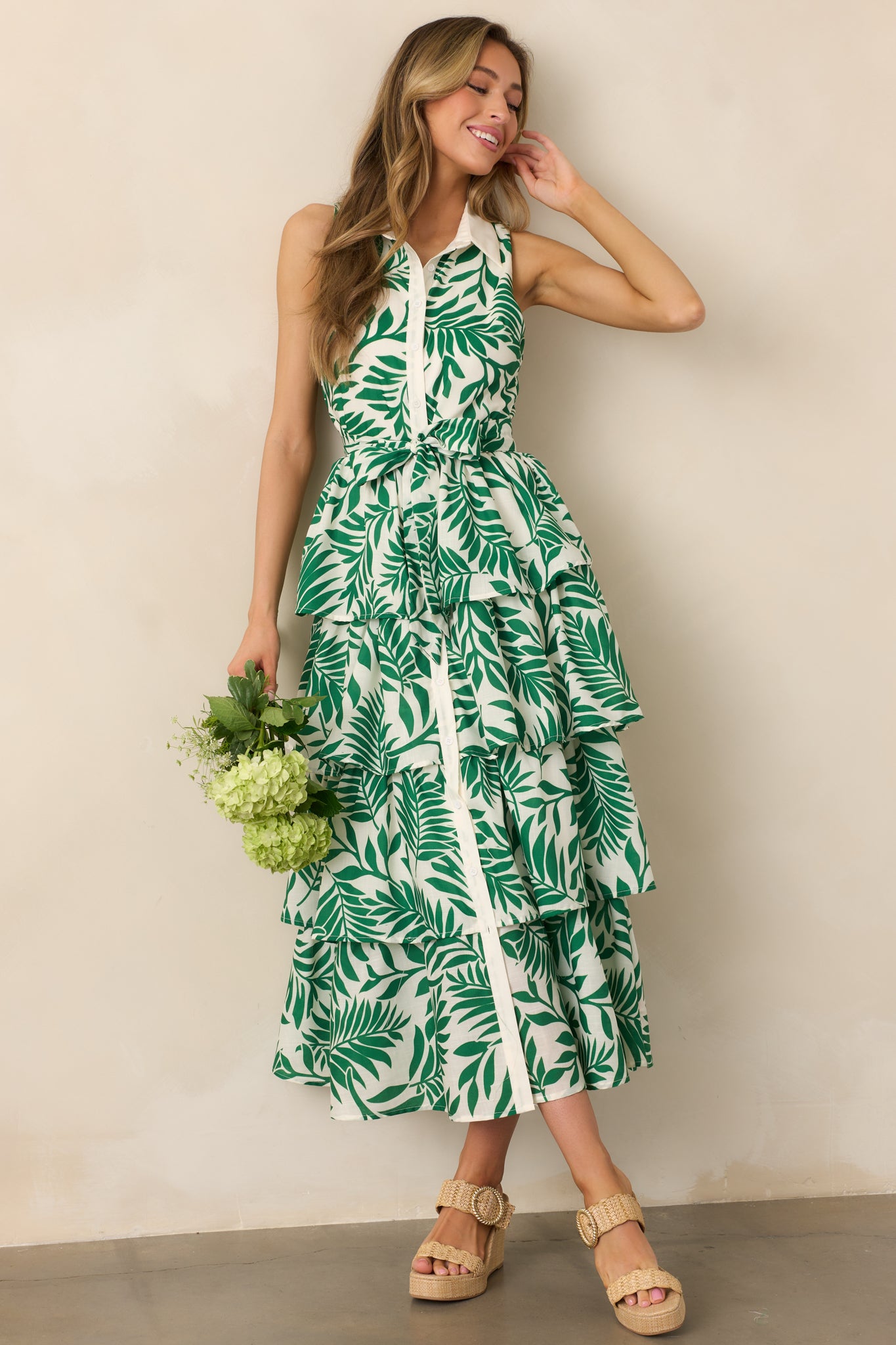  A full-length green floral midi dress featuring a collared neckline, button front, self-tie waistband, and tiered skirt, creating a relaxed, elegant silhouette.