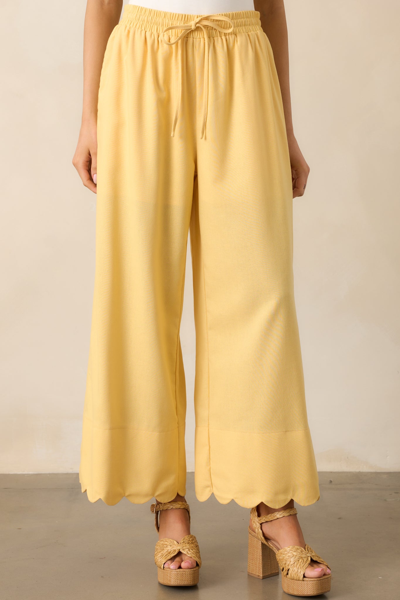 A closer look at the high-waisted fit and adjustable self-tie waistband, adding a customizable touch to these yellow pants.