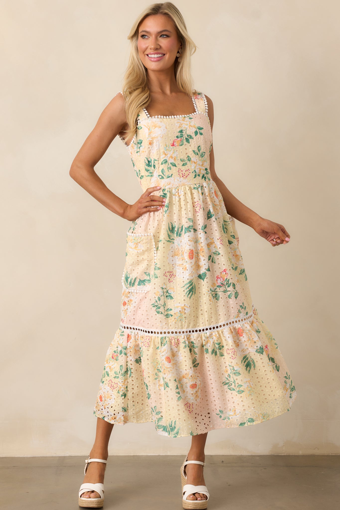  Elegant yellow dress with embroidered details on the skirt and a smocked back for a comfortable yet fitted design.