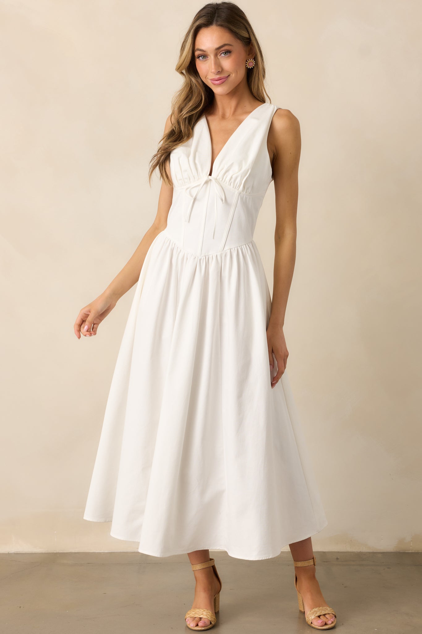 The V-waistline creates a flattering shape, complementing the sleek and sophisticated design of this white dress.