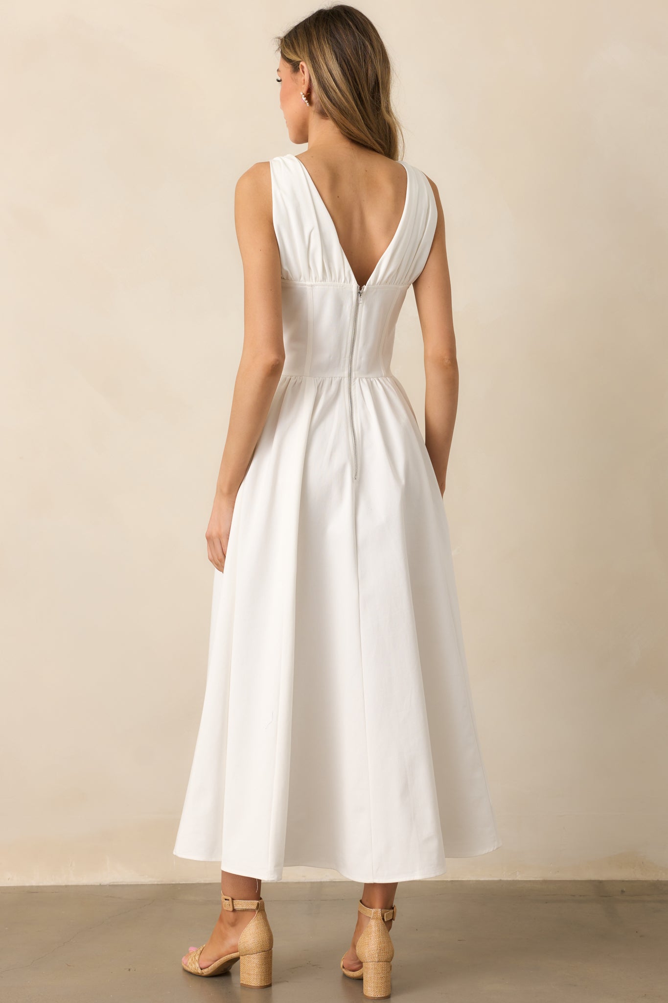 The functional back zipper ensures a seamless and polished look, completing the refined design of this white dress.