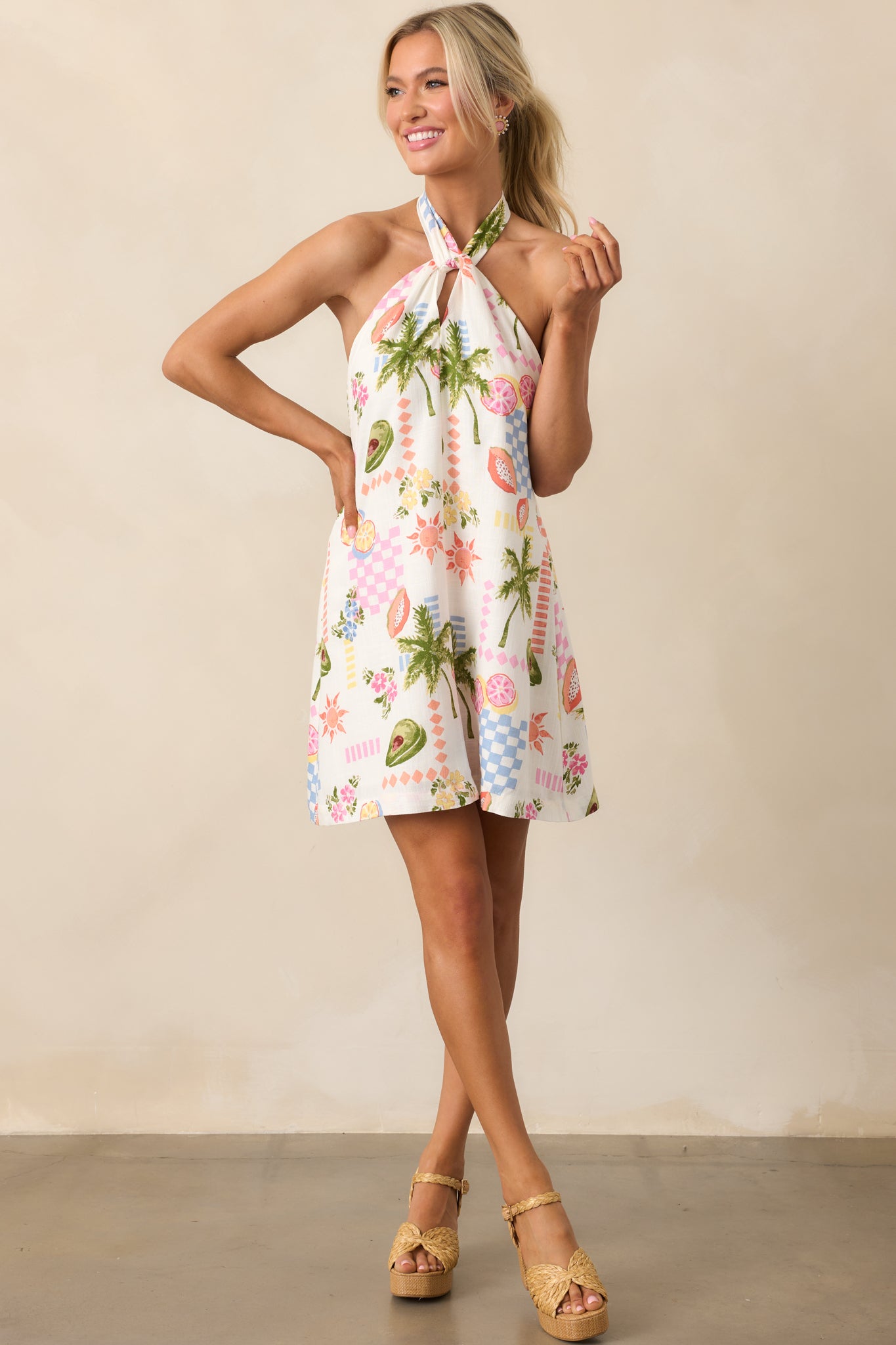 Vibrant tropical print dress featuring a halter neck tie and a flowy silhouette, perfect for warm-weather styling.