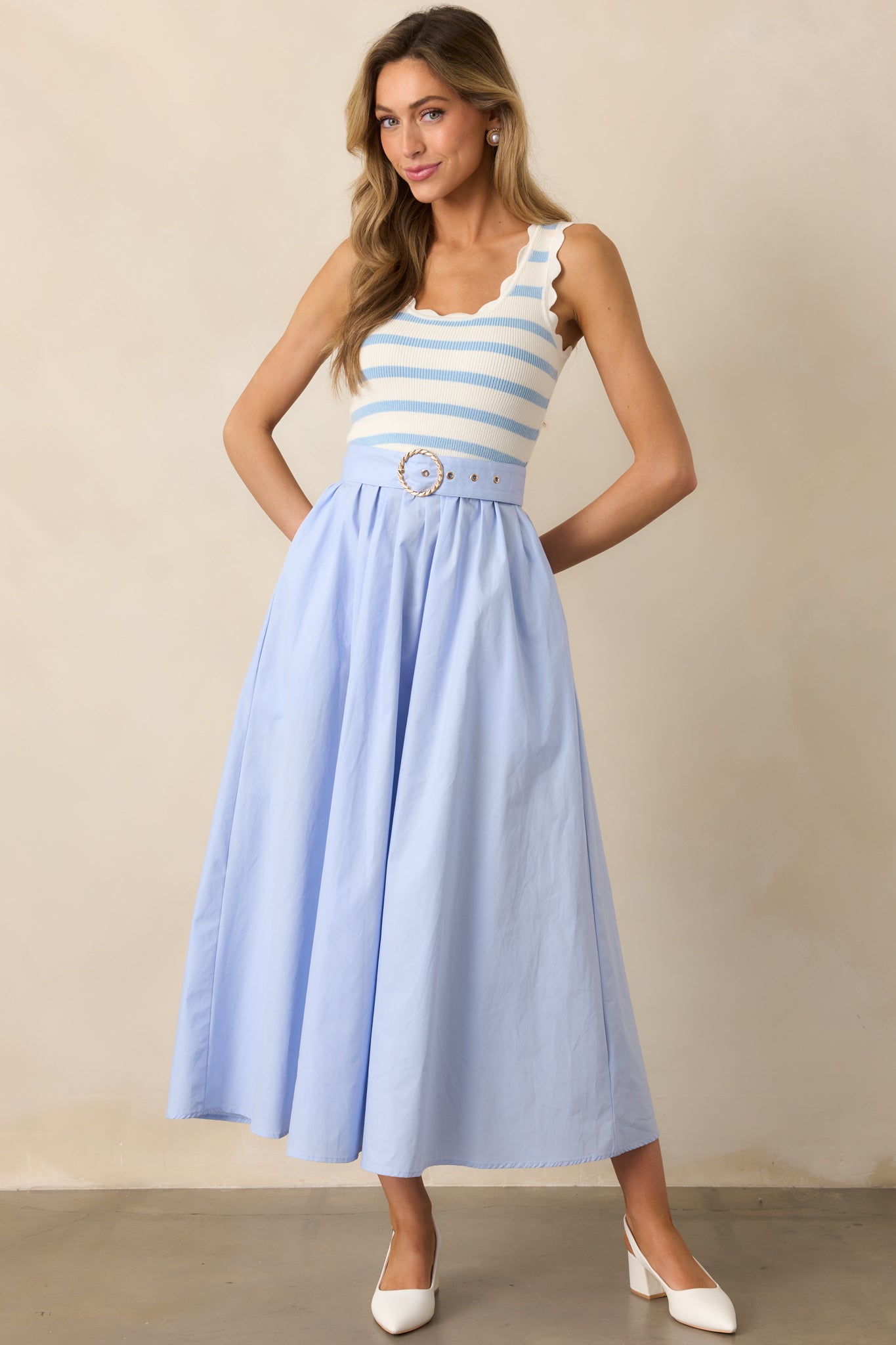 The scalloped hems on the striped knit top add a delicate detail, complementing the flowy solid skirt.