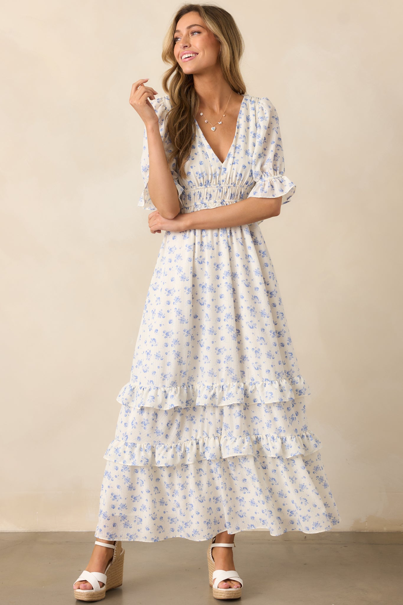  A flowy ivory dress with a tiered ruffle design, showcasing an elegant mix of floral print and soft textures.