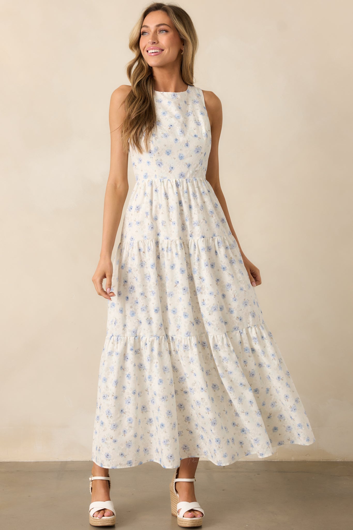 A front-facing view of the ivory dress, highlighting its delicate blue floral pattern and tiered structure for added movement.