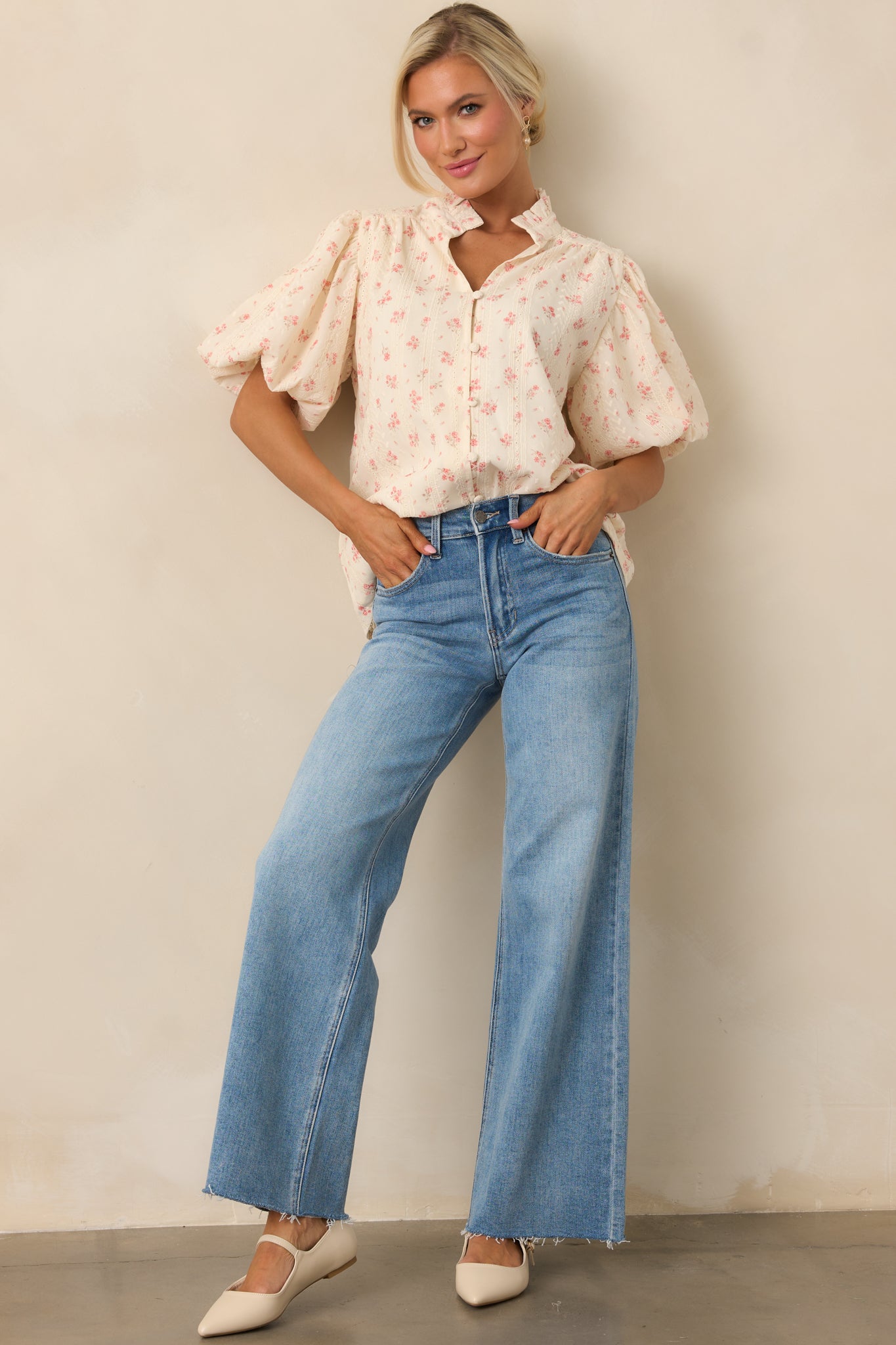 A pair of high-waisted jeans featuring a wide straight-leg fit, functional pockets, and a raw bottom hem for a relaxed, modern look.