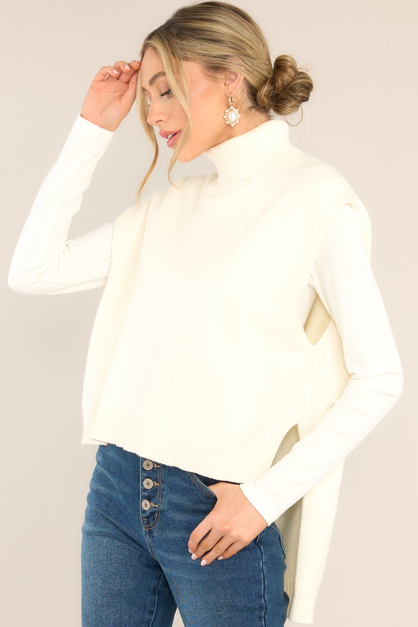 Side view of this sweater vest that features a relaxed-fit, turtleneck sweater vest in soft, rib-knit fabric with wool content. Slits at sides of hem and longer at back.